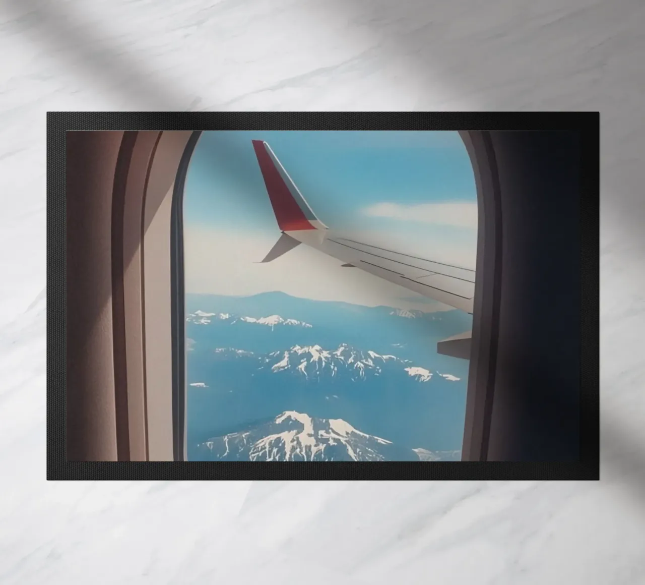 Vue d'un hublot d'avion sur une aile et des montagnes paillasson de DesignDoodle