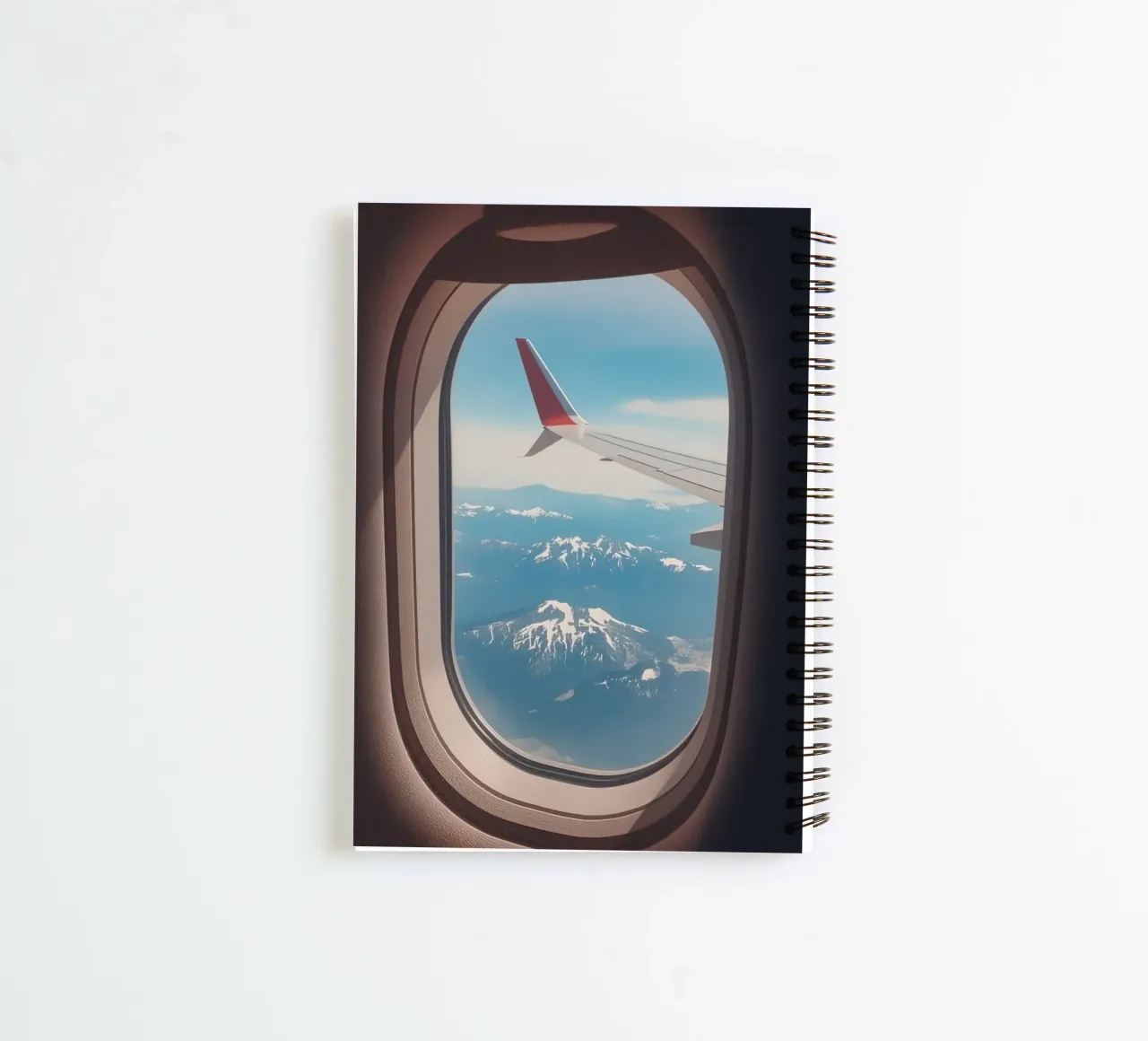 Vue d'un hublot d'avion sur une aile et des montagnes carnet à spirale de DesignDoodle