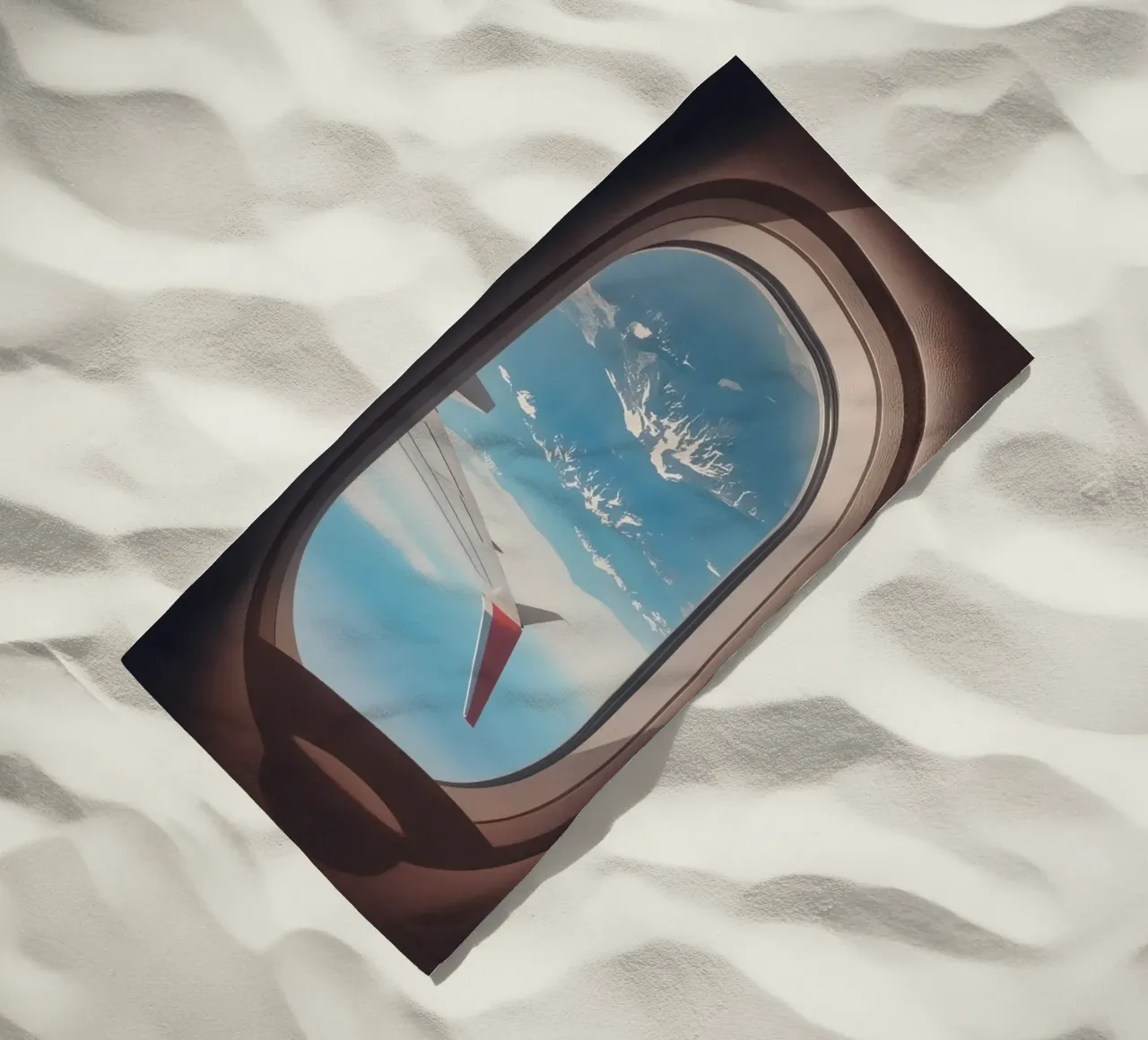 Vue d'un hublot d'avion sur une aile et des montagnes serviette de plage de DesignDoodle