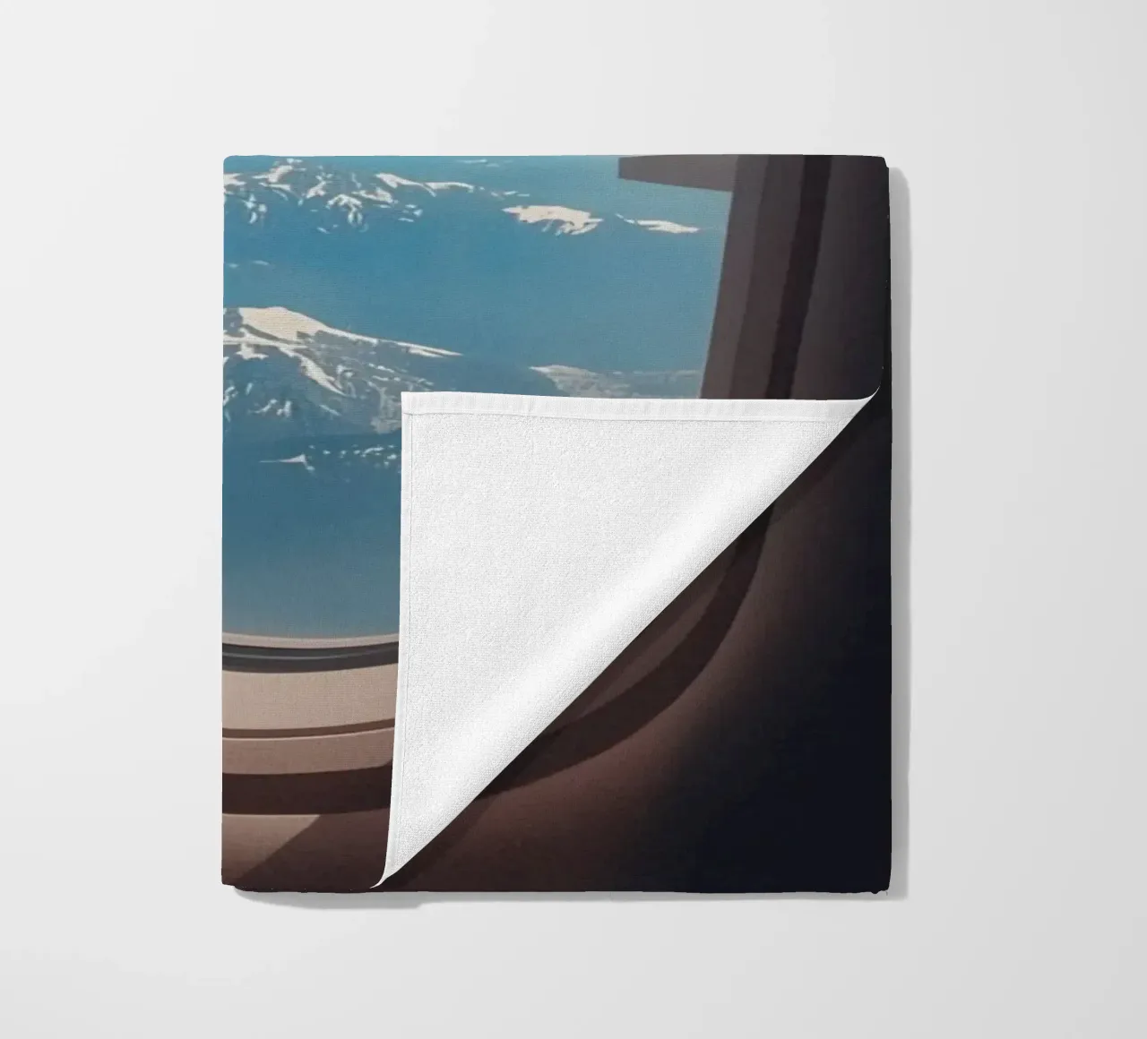 Vue d'un hublot d'avion sur une aile et des montagnes serviette de plage de DesignDoodle