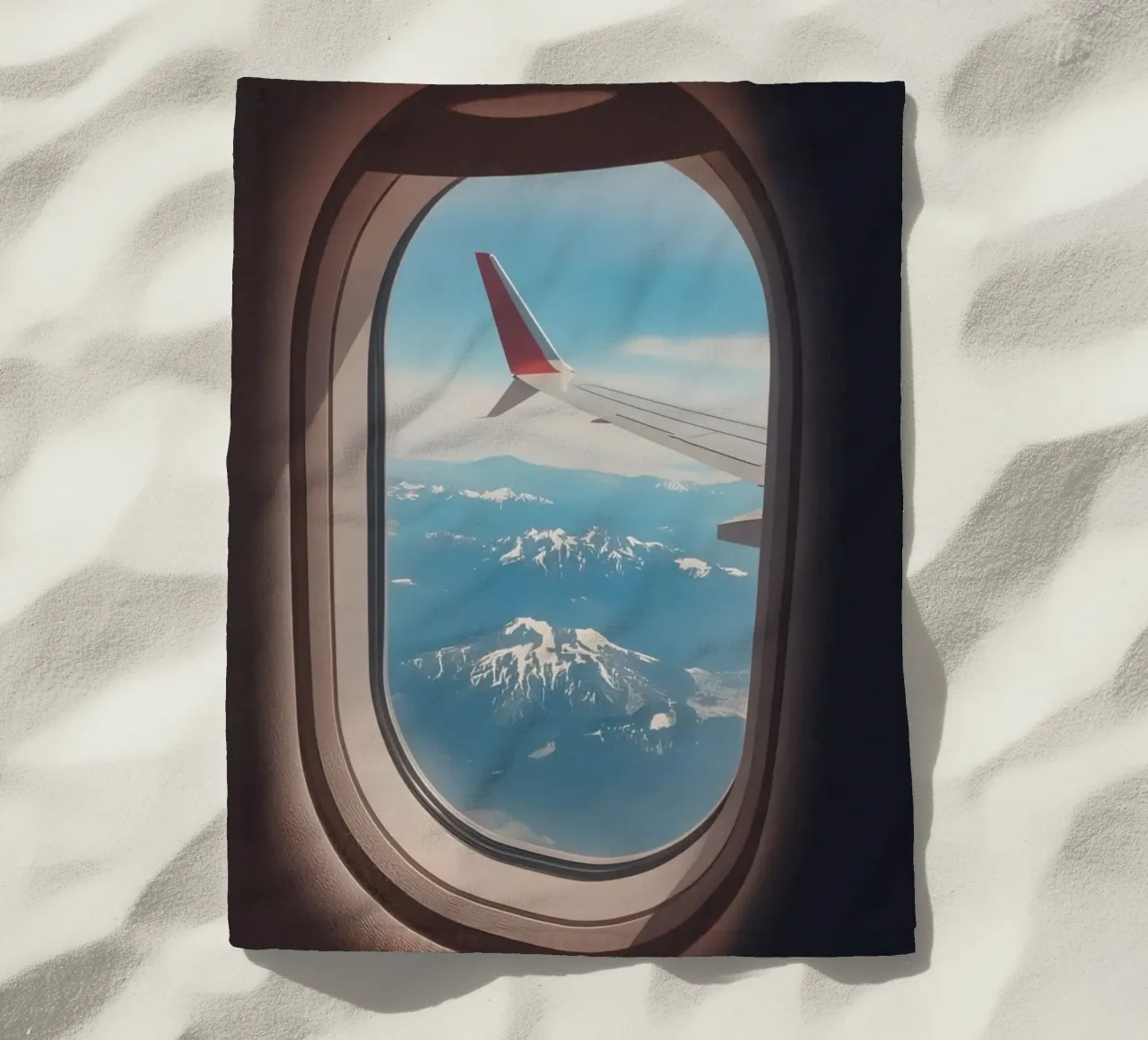 Vue d'un hublot d'avion sur une aile et des montagnes serviette de plage de DesignDoodle