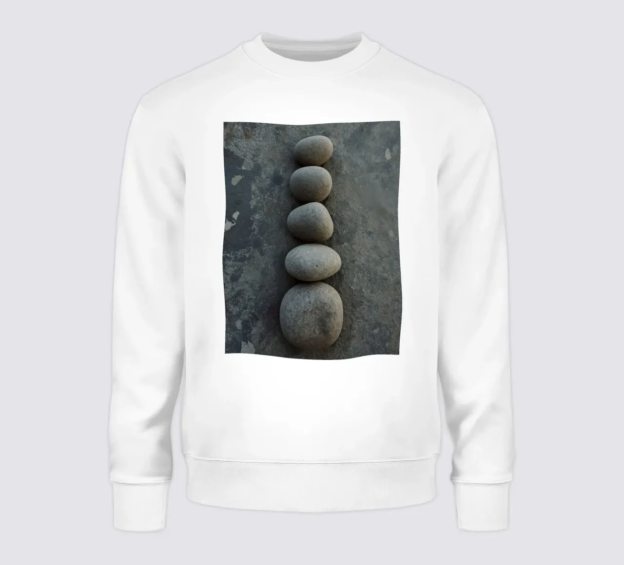 Cinque pietre grigie impilate verticalmente su una superficie strutturata felpa da DesignDoodle