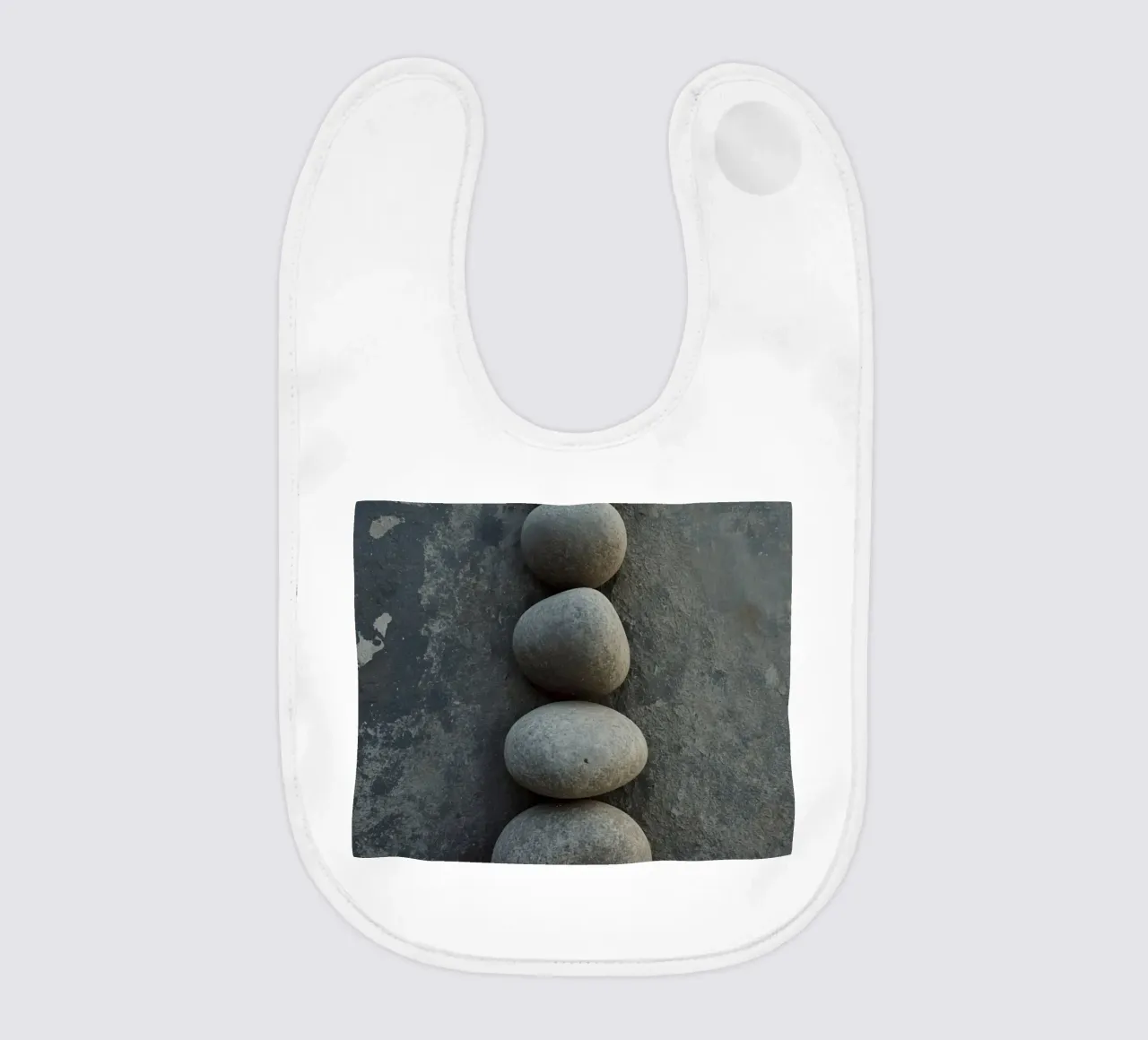 Cinque pietre grigie impilate verticalmente su una superficie strutturata bavaglino da DesignDoodle