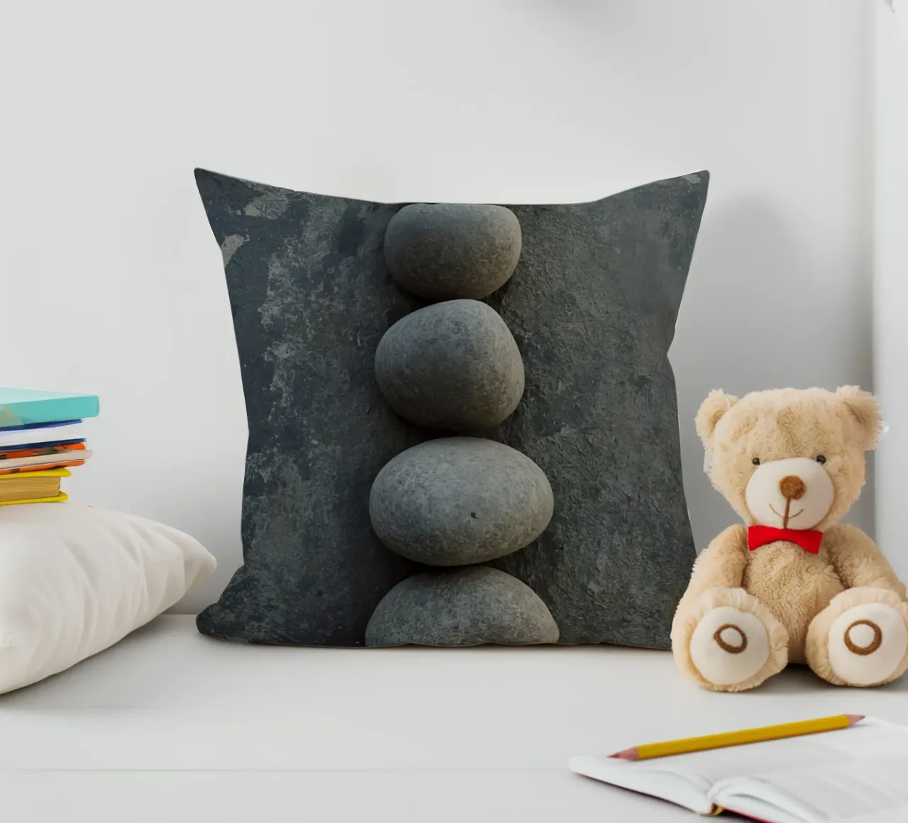 Cinque pietre grigie impilate verticalmente su una superficie strutturata cuscino da DesignDoodle