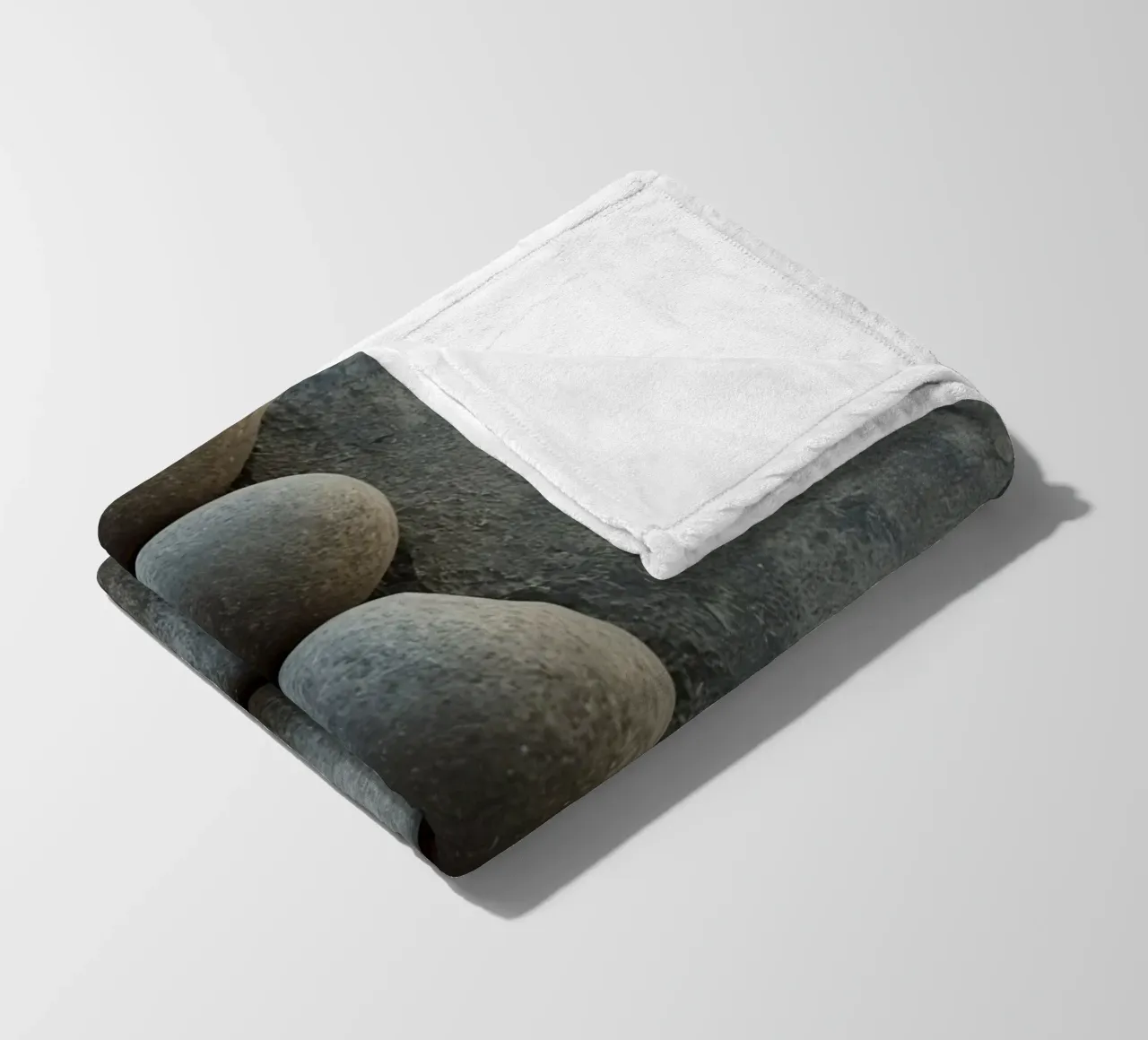 Cinque pietre grigie impilate verticalmente su una superficie strutturata coperta in pile da DesignDoodle