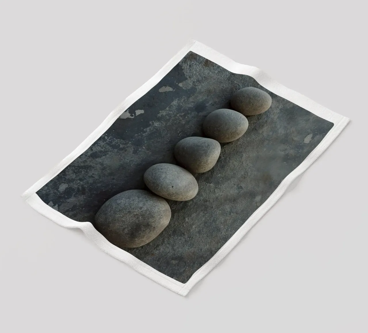 Cinque pietre grigie impilate verticalmente su una superficie strutturata coperta in pile da DesignDoodle
