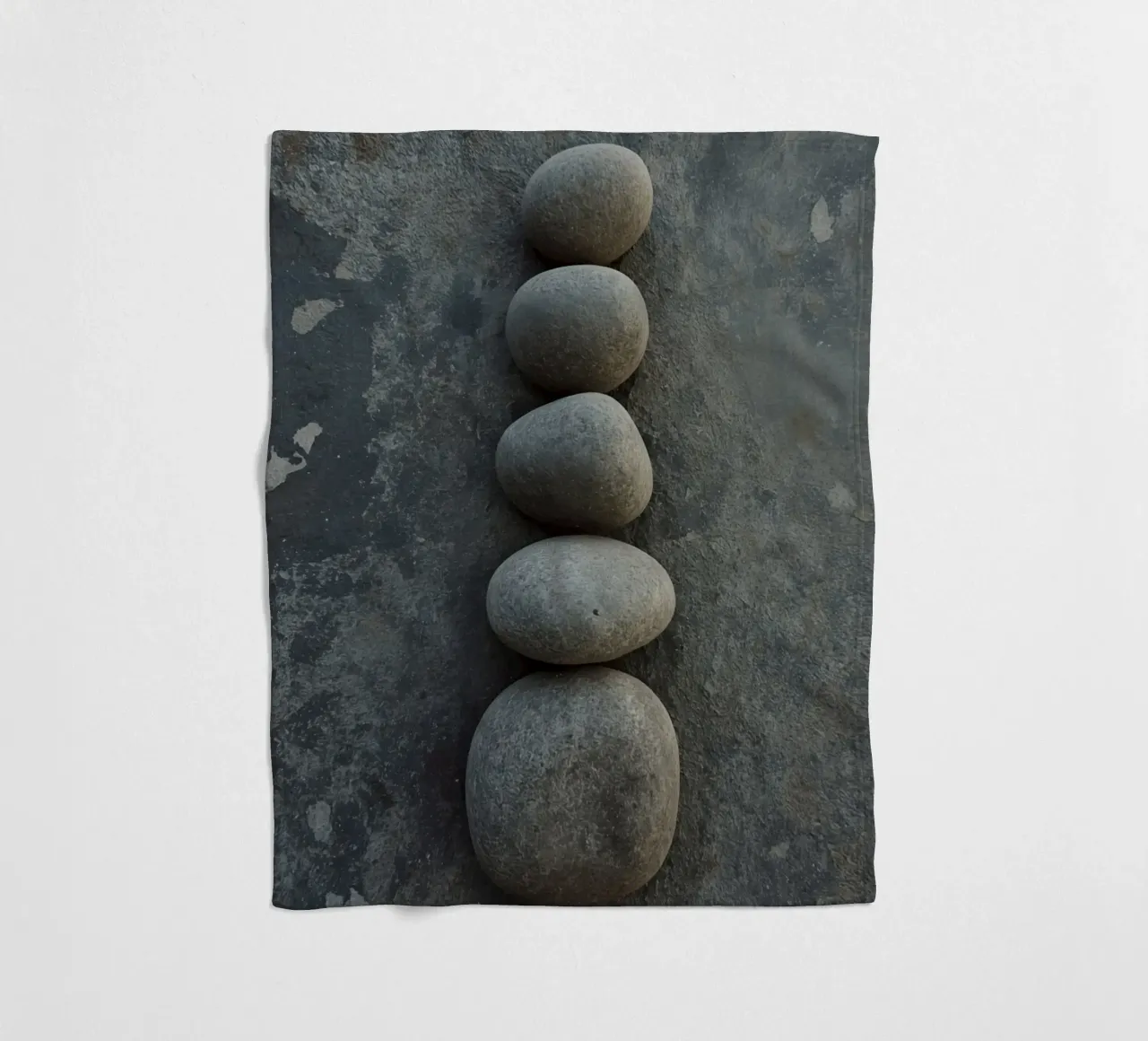 Cinque pietre grigie impilate verticalmente su una superficie strutturata coperta in pile da DesignDoodle