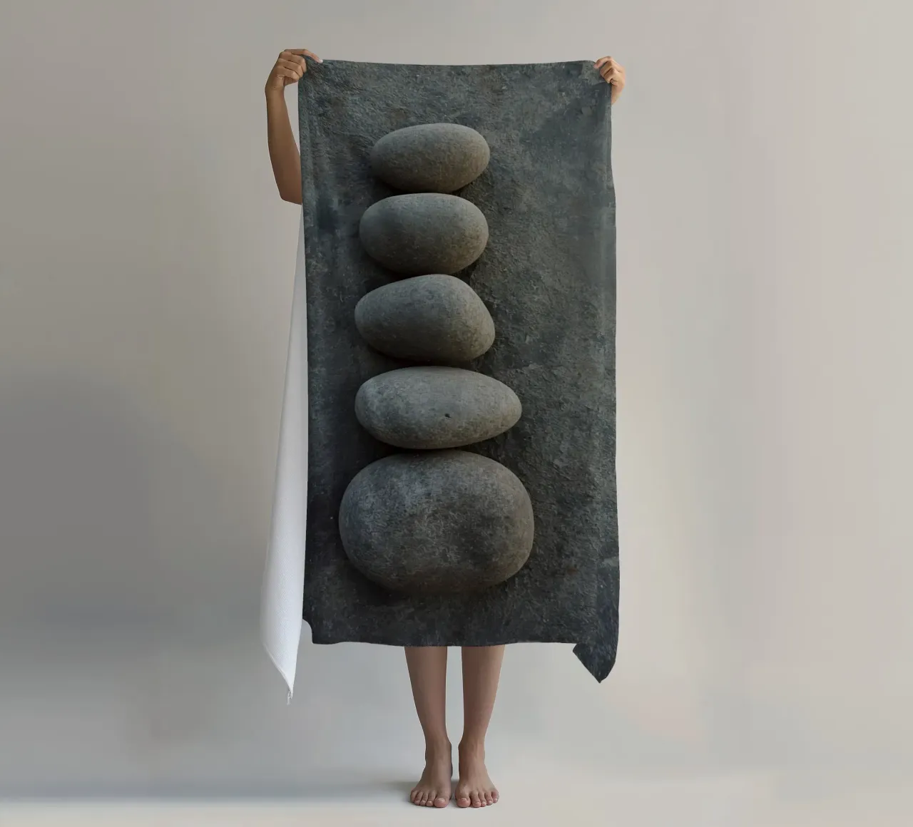 Cinque pietre grigie impilate verticalmente su una superficie strutturata telo mare da DesignDoodle