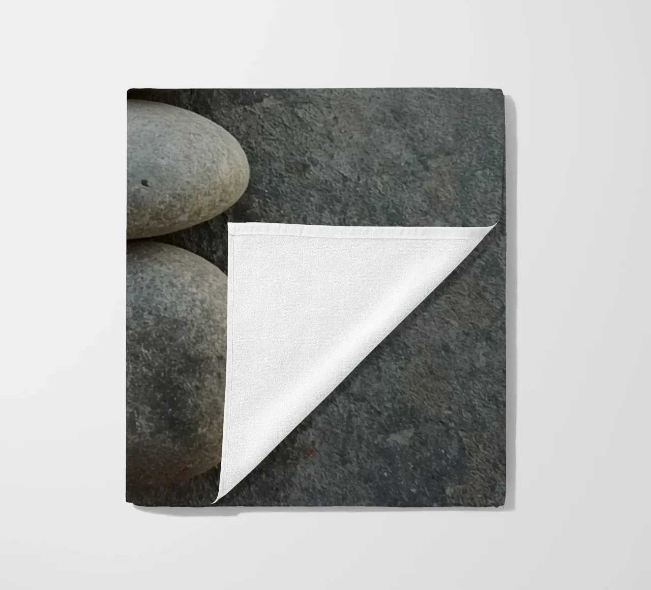Cinque pietre grigie impilate verticalmente su una superficie strutturata telo mare da DesignDoodle