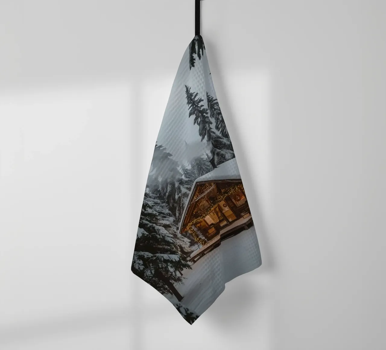 Cabane enneigée dans la forêt avec des lumières de Noël torchon de DesignDoodle