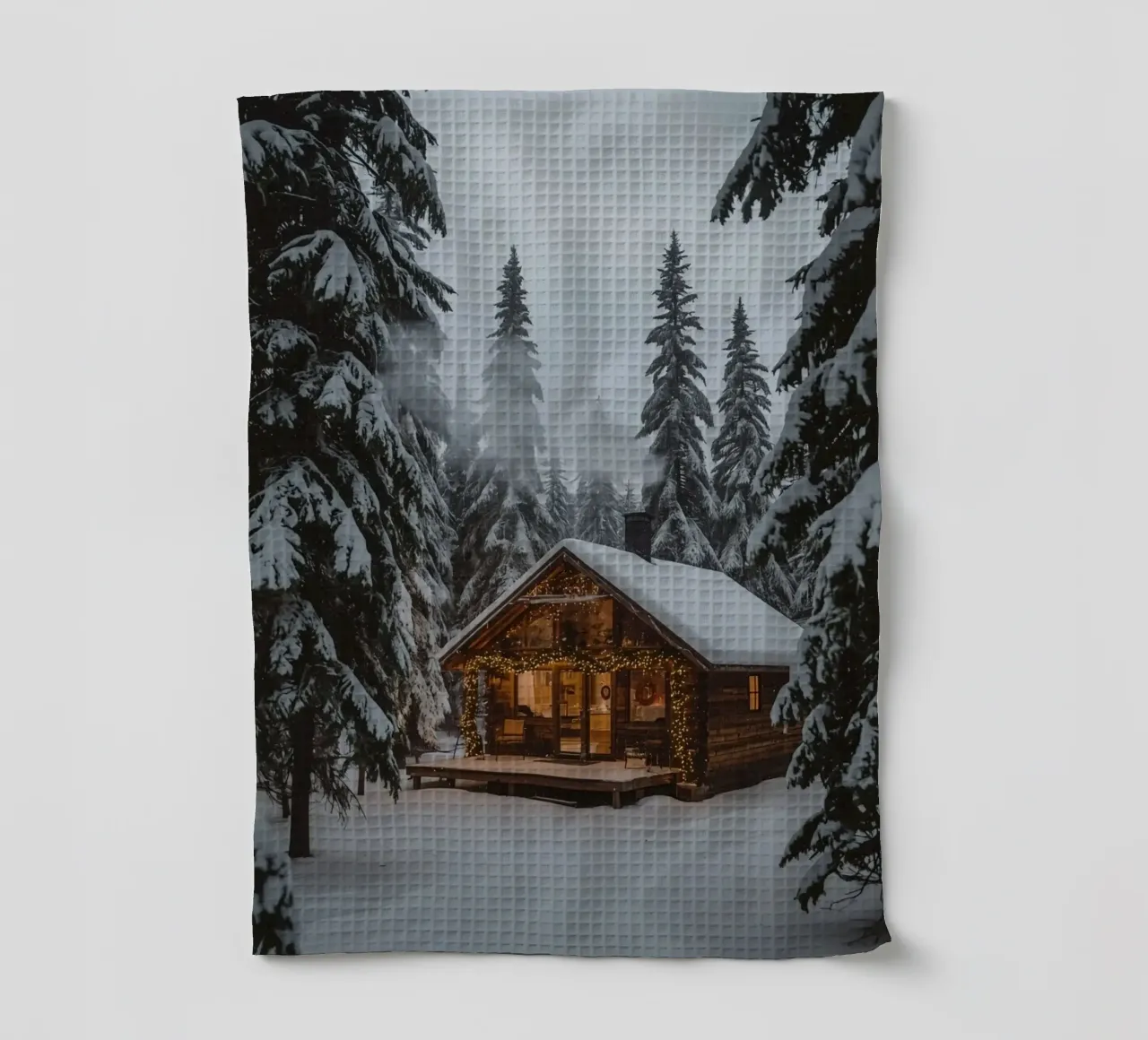 Cabane enneigée dans la forêt avec des lumières de Noël torchon de DesignDoodle