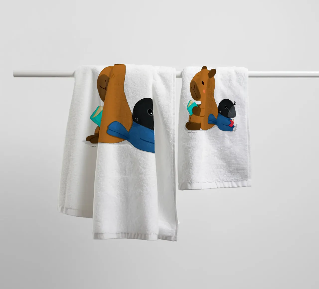 Capybara and Bird reading books towel by julianamotzko