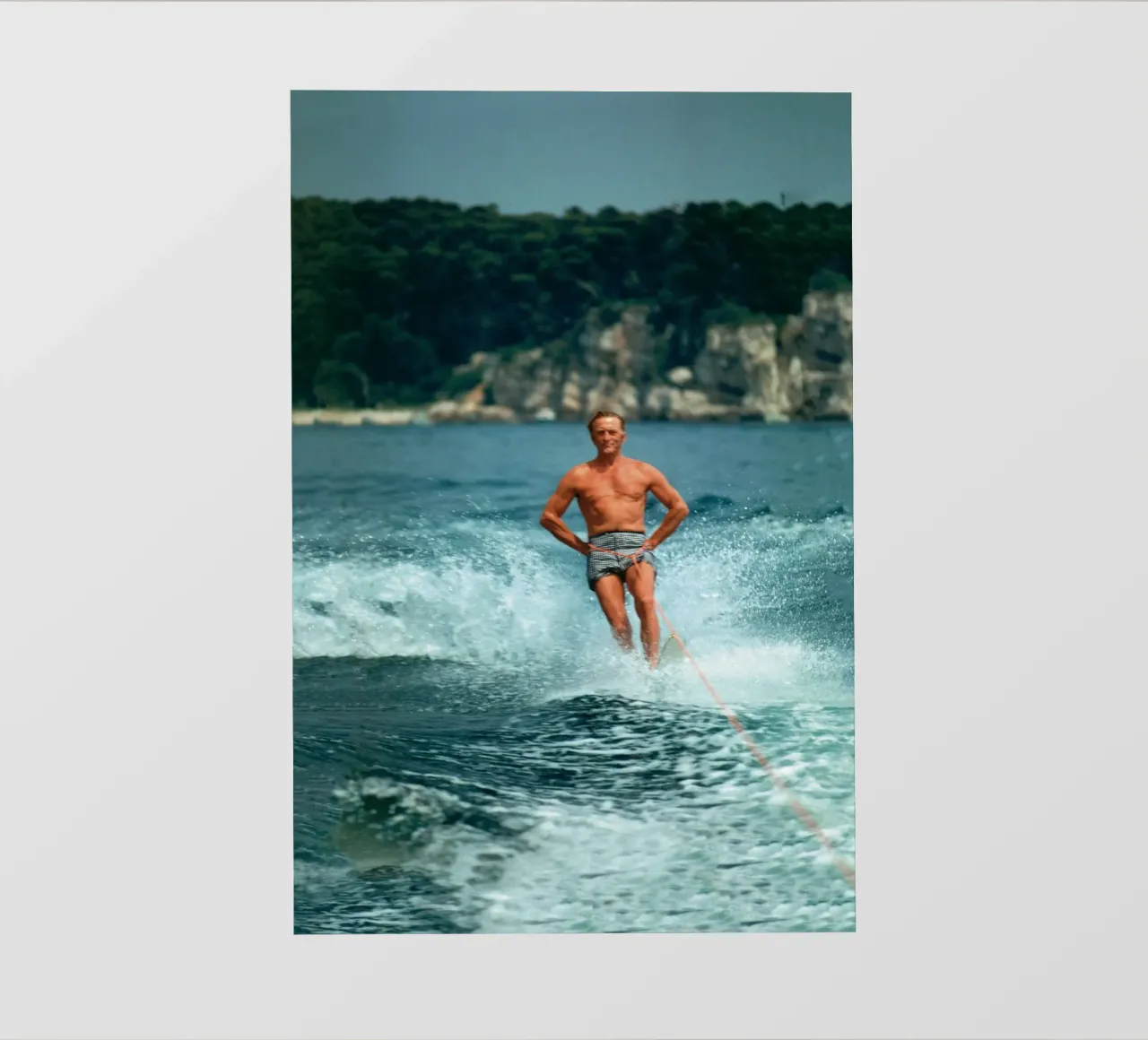 Giocare in mare facendo surf - Slim Aarons telo in pvc da The Poster UK