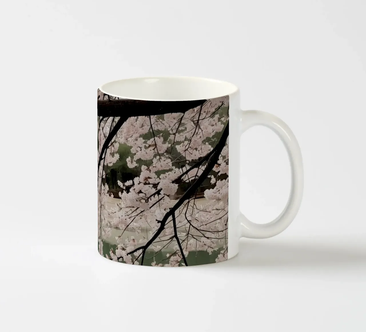 Rami di ciliegio in fiore sull'acqua con riflessi tazza in ceramica da DesignDoodle