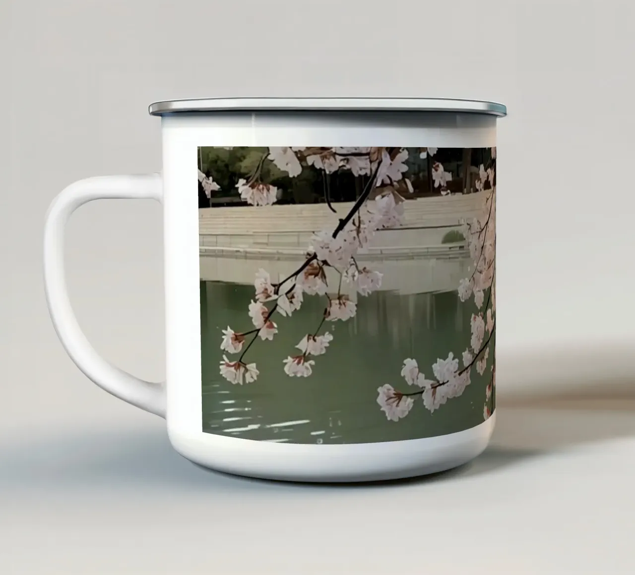 Rami di ciliegio in fiore sull'acqua con riflessi tazza in smalto da DesignDoodle