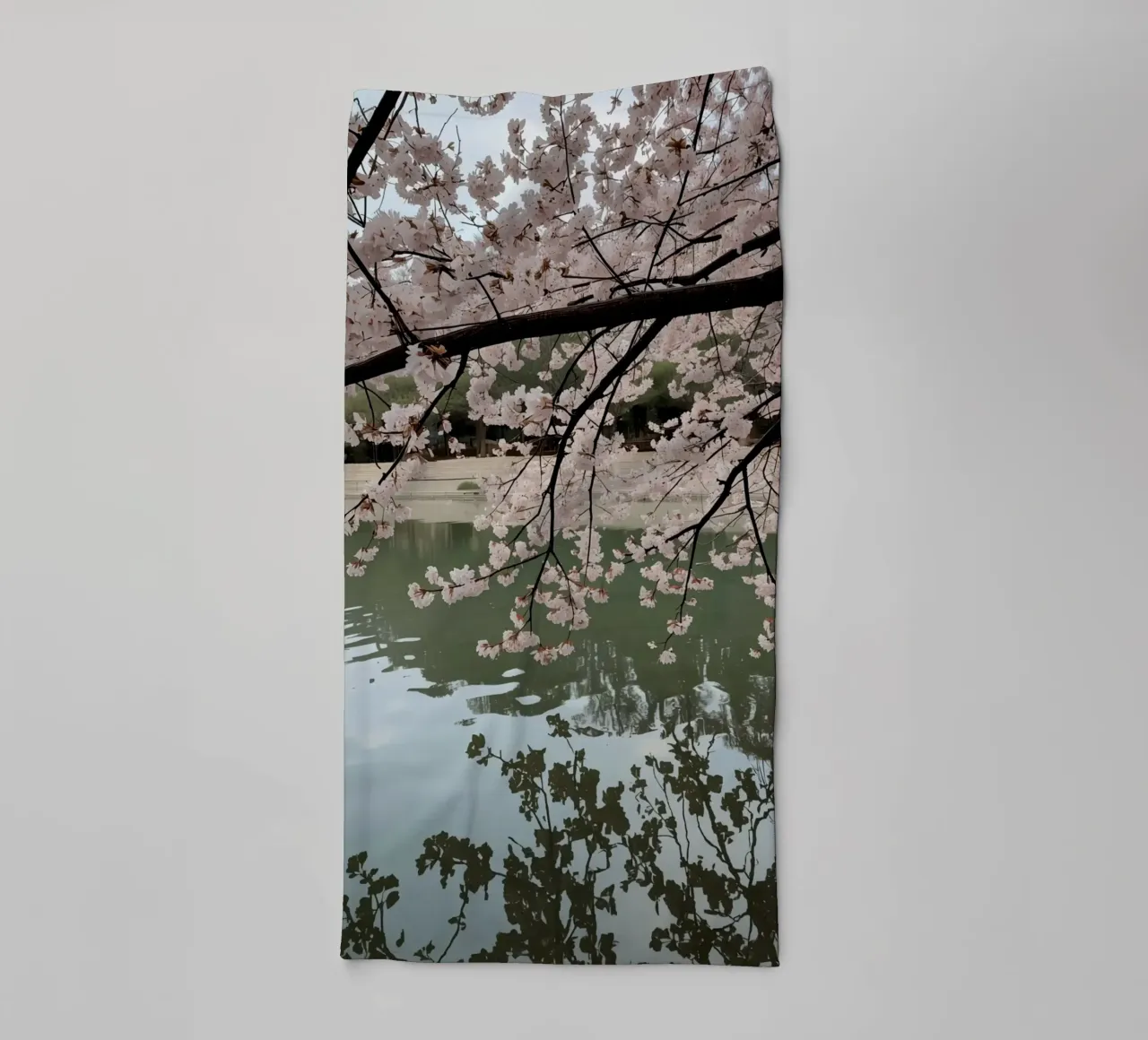 Rami di ciliegio in fiore sull'acqua con riflessi asciugamano da bagno da DesignDoodle