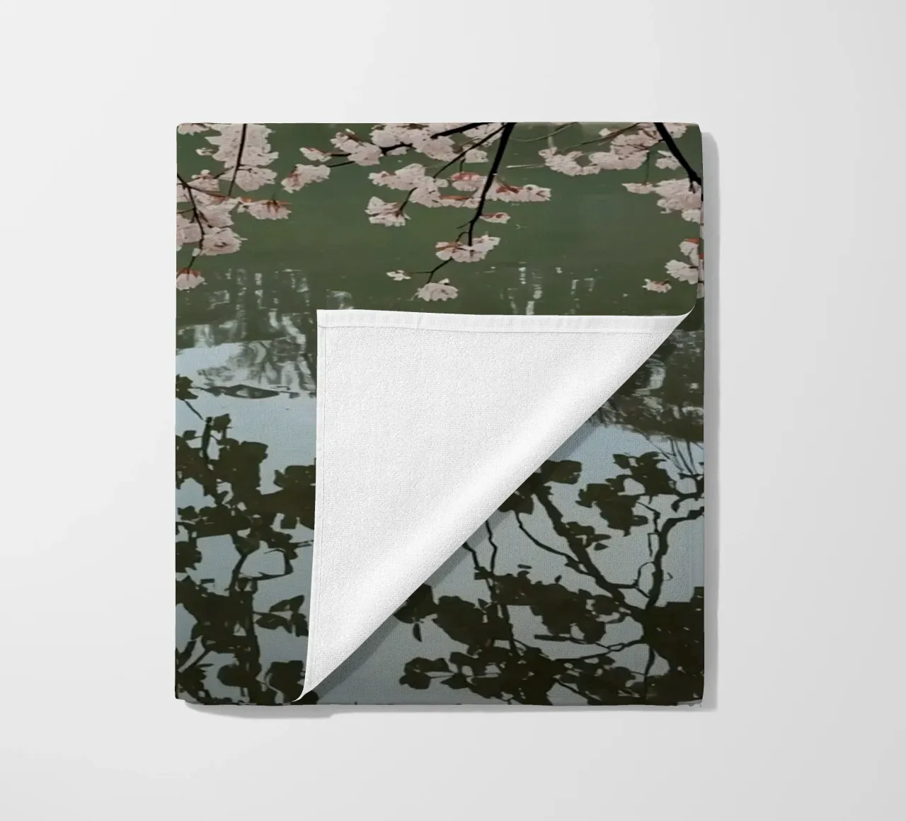 Rami di ciliegio in fiore sull'acqua con riflessi telo mare da DesignDoodle