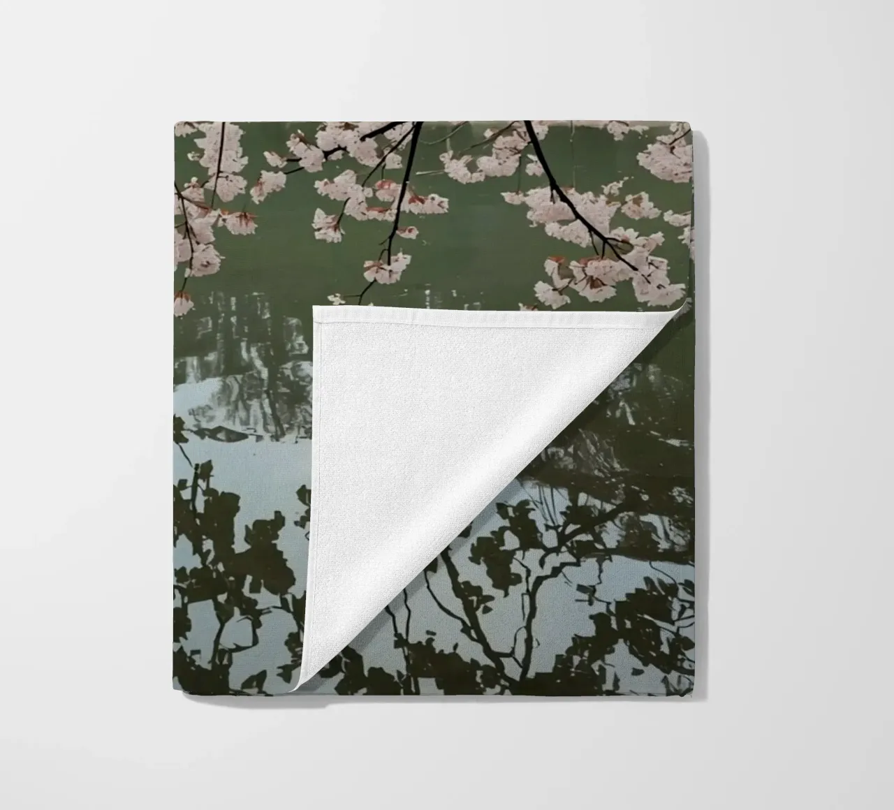 Rami di ciliegio in fiore sull'acqua con riflessi telo mare da DesignDoodle