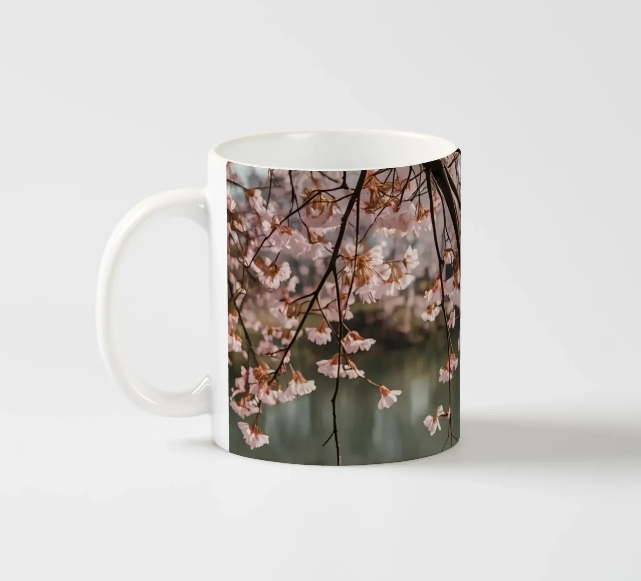 Rami di ciliegio in fiore sull'acqua tazza in ceramica da DesignDoodle