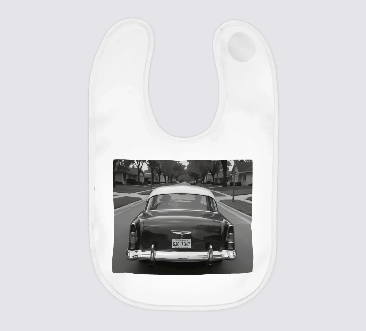 Vista posteriore di un'auto d'epoca su una strada in bianco e nero bavaglino da DesignDoodle