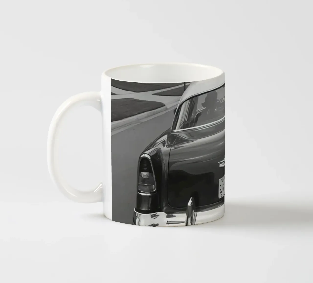 Vista posteriore di un'auto d'epoca su una strada in bianco e nero tazza in ceramica da DesignDoodle