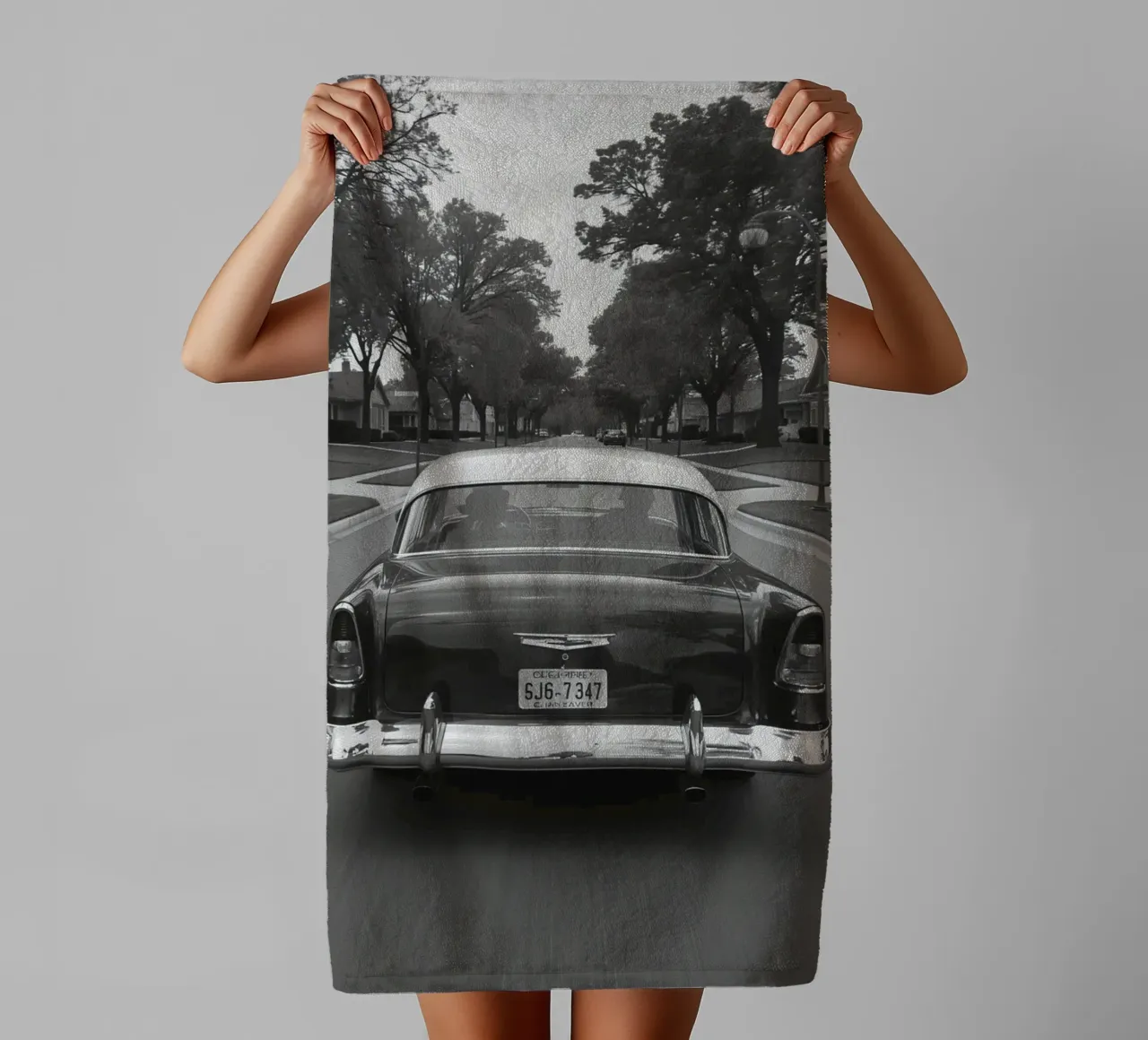 Vue arrière d'une voiture classique dans une rue en noir et blanc serviette de bain de DesignDoodle