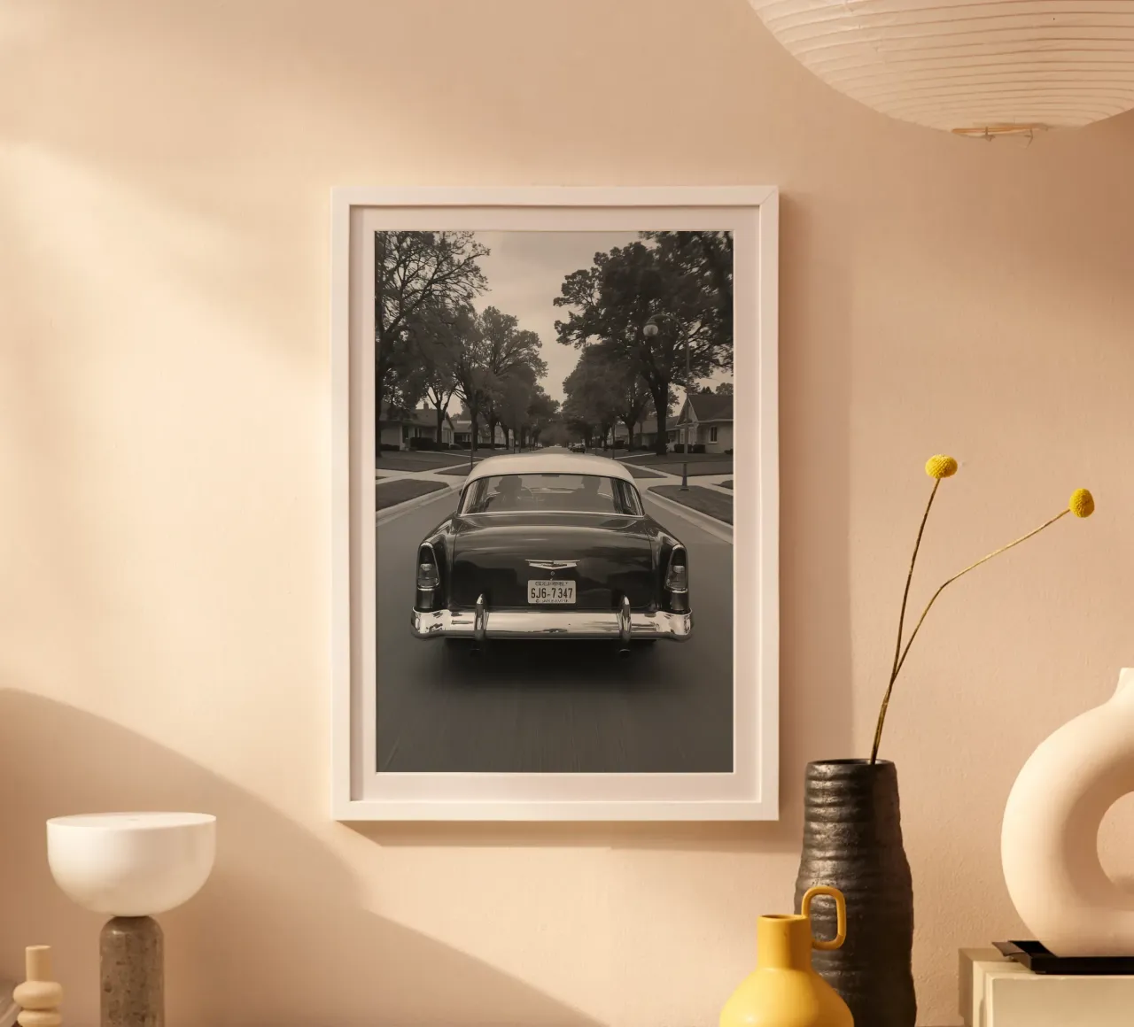 Vue arrière d'une voiture classique dans une rue en noir et blanc poster avec cadre en plastique de DesignDoodle