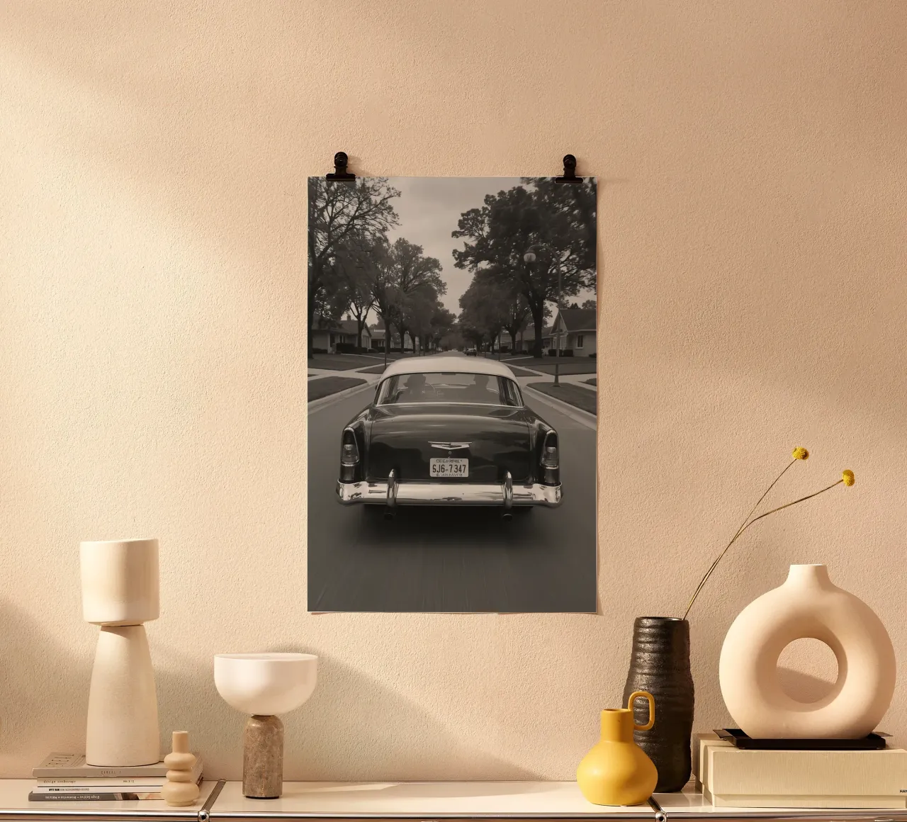 Vue arrière d'une voiture classique dans une rue en noir et blanc poster avec cadre en plastique de DesignDoodle