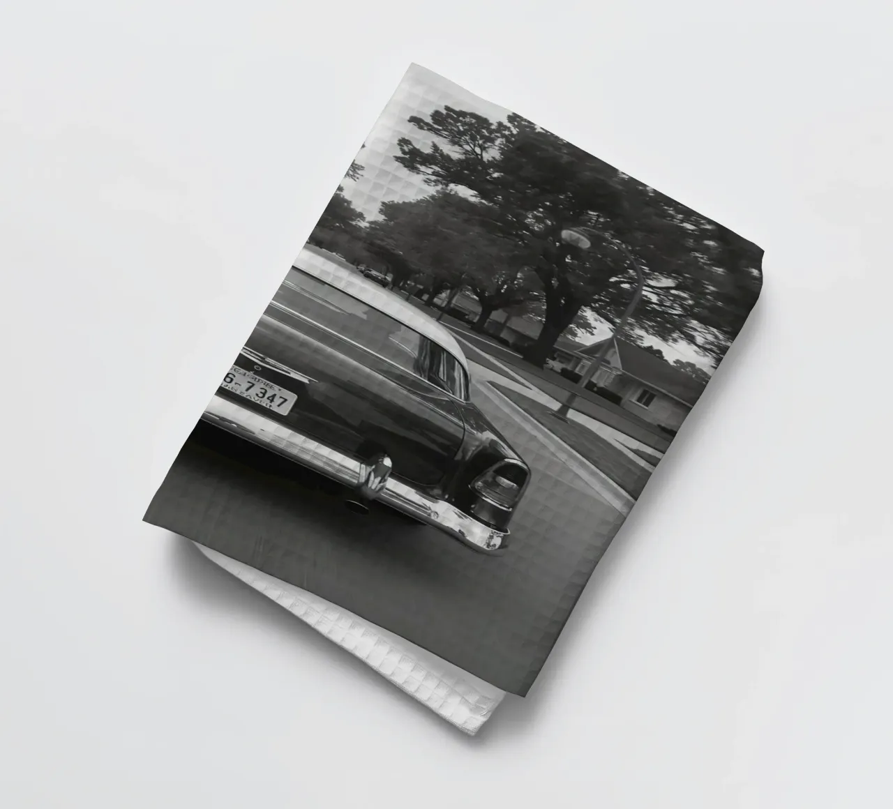 Vue arrière d'une voiture classique dans une rue en noir et blanc torchon de DesignDoodle