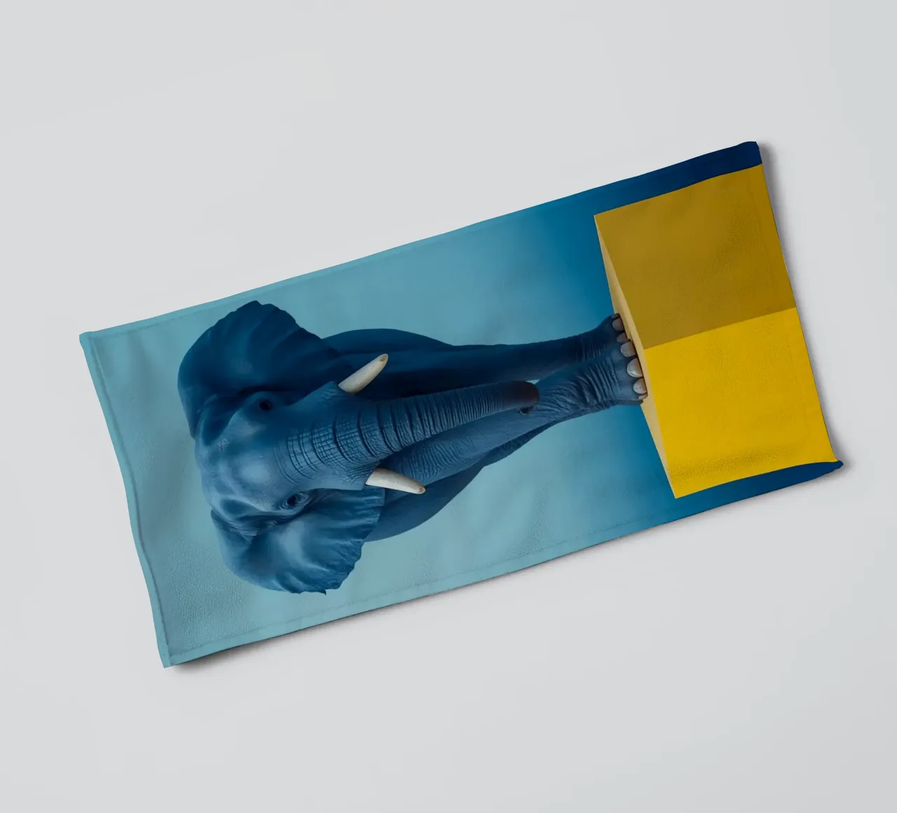 Eléphant bleu debout sur un cube jaune serviette de bain de DesignDoodle
