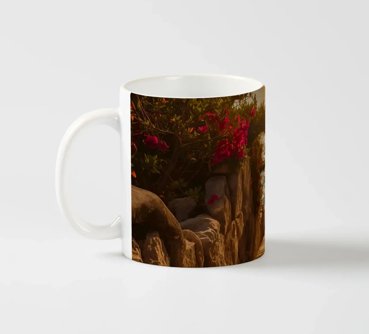 Scala in pietra con fiori che conduce alla vista dell'oceano al tramonto tazza in ceramica da DesignDoodle