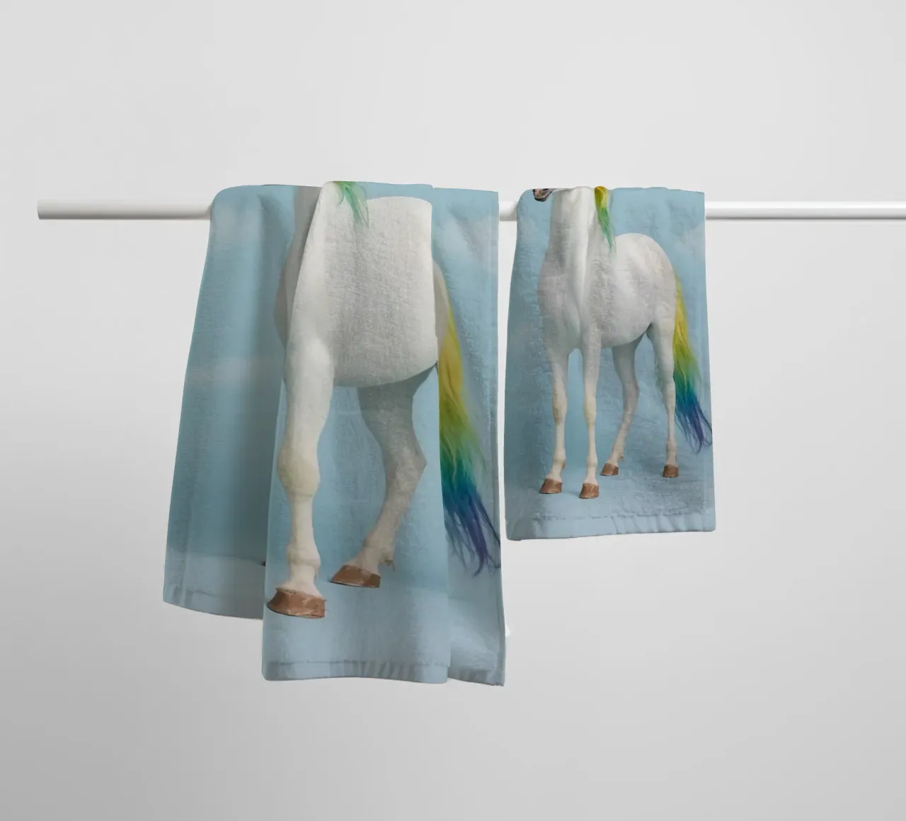 White Unicorn with Rainbow Mane and Tail on Blue Background towel by DesignDoodle