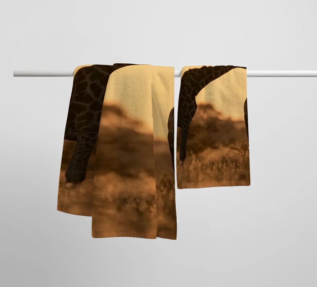 A giraffe standing on the meadow in the afternoon towel by Earthly Visions