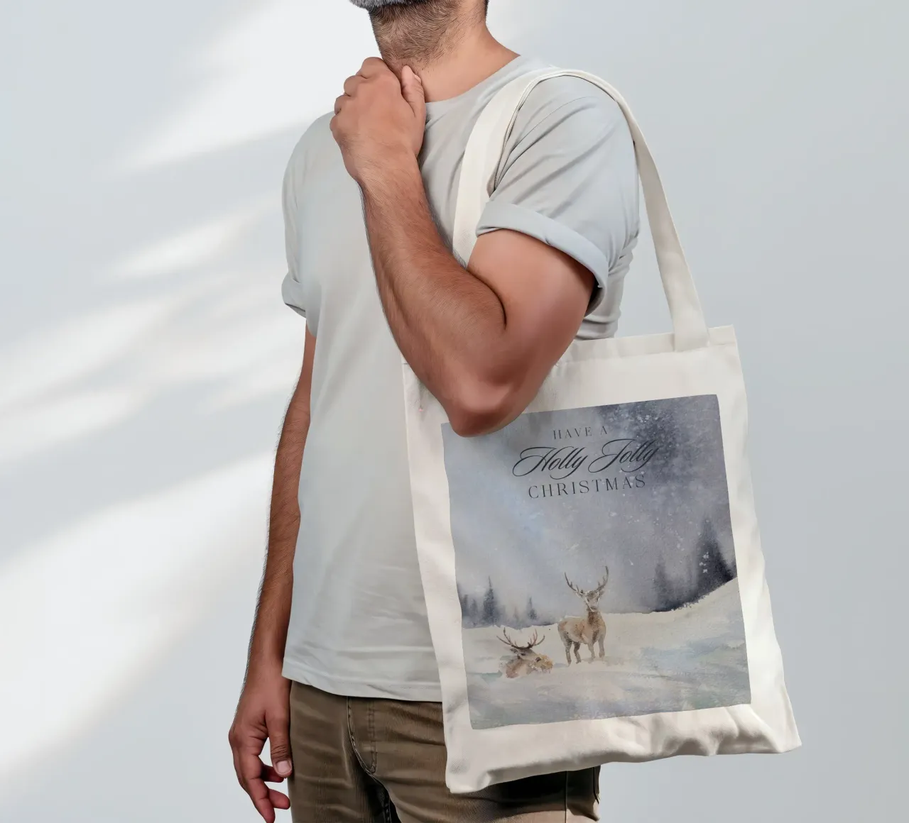 Renne in un bosco invernale con la scritta Have a Holly Jolly Chr borsa in juta da Studio Vibe