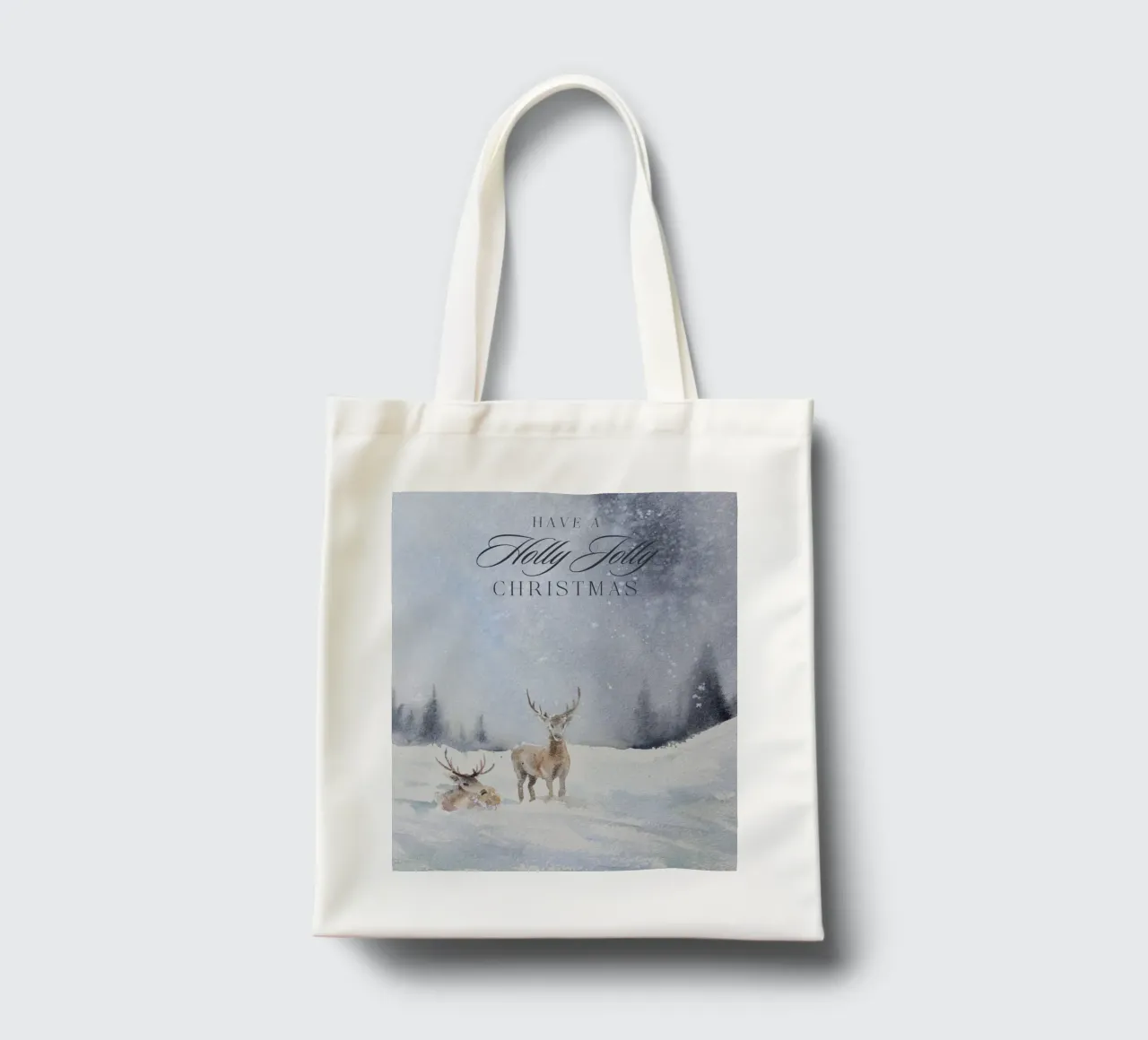 Renne in un bosco invernale con la scritta Have a Holly Jolly Chr borsa in juta da Studio Vibe