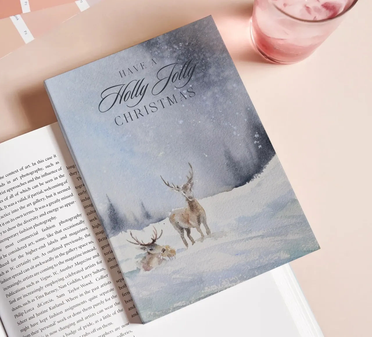 Reindeer in a winter forest with the lettering Have a Holly Jolly Chr notebook by Studio Vibe