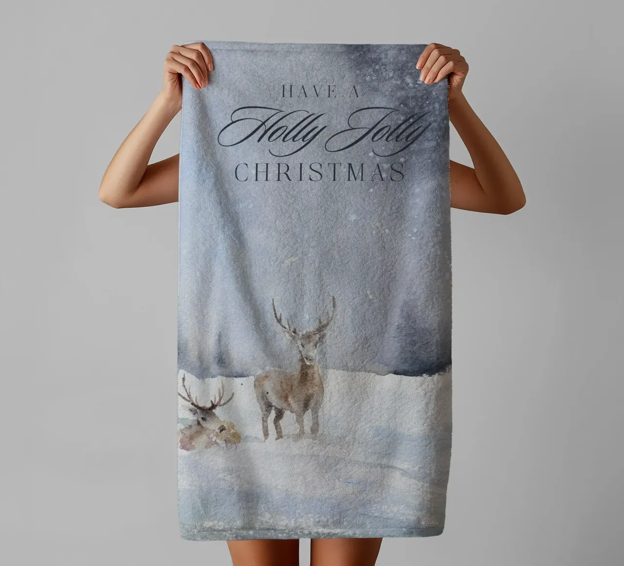 Reindeer in a winter forest with the lettering Have a Holly Jolly Chr towel by Studio Vibe