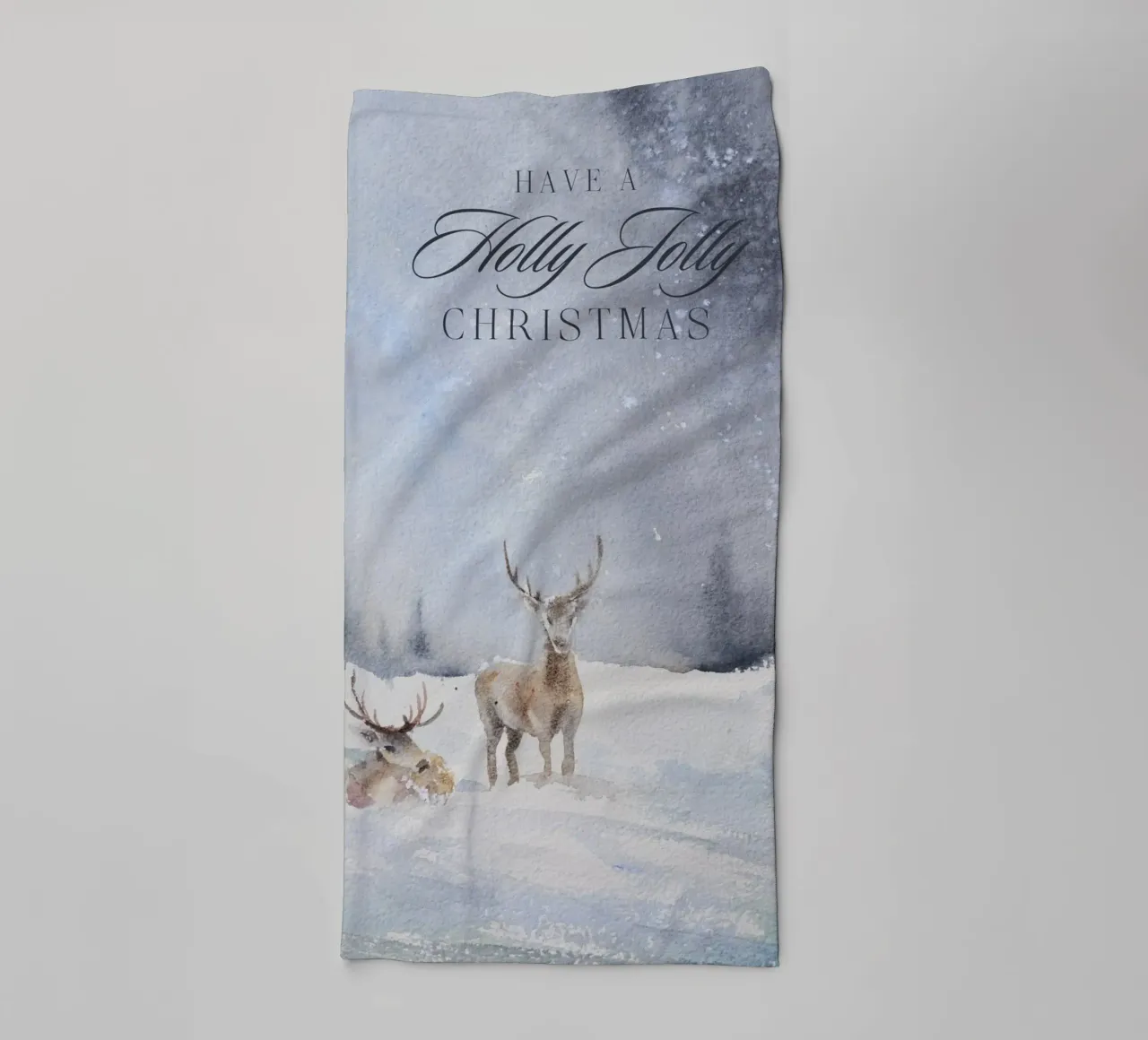 Reindeer in a winter forest with the lettering Have a Holly Jolly Chr towel by Studio Vibe