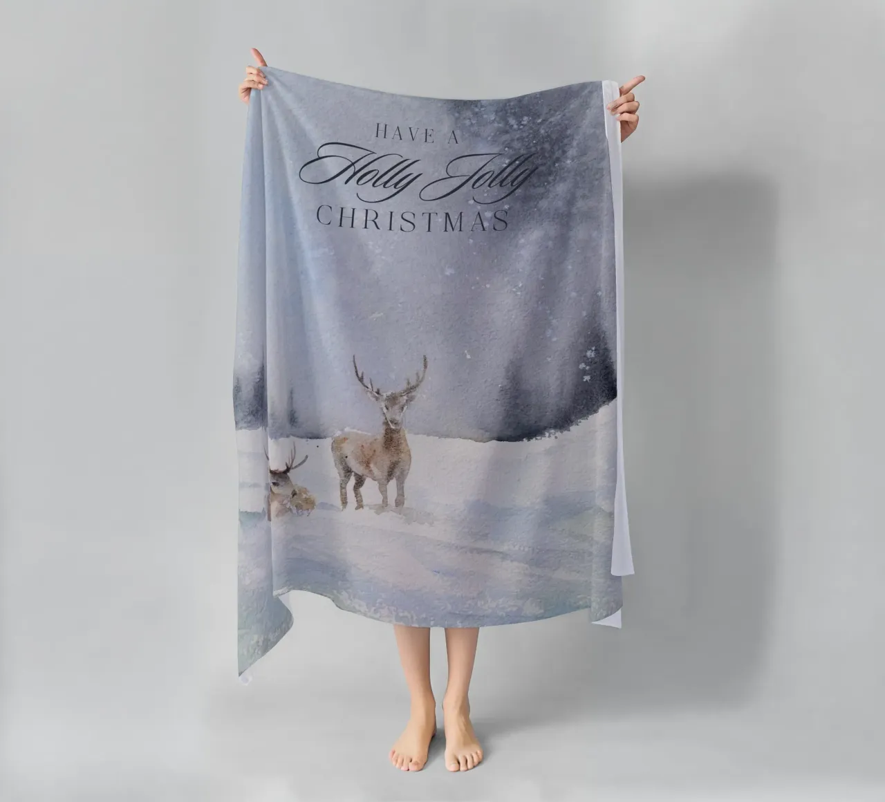 Renne in un bosco invernale con la scritta Have a Holly Jolly Chr telo mare da Studio Vibe