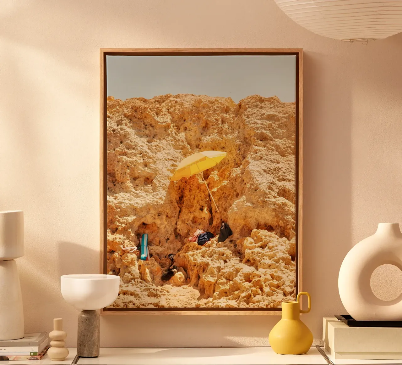 Shelter in the Rocks – The Yellow Umbrella canvas with Floater frame by Thilo Grøsch