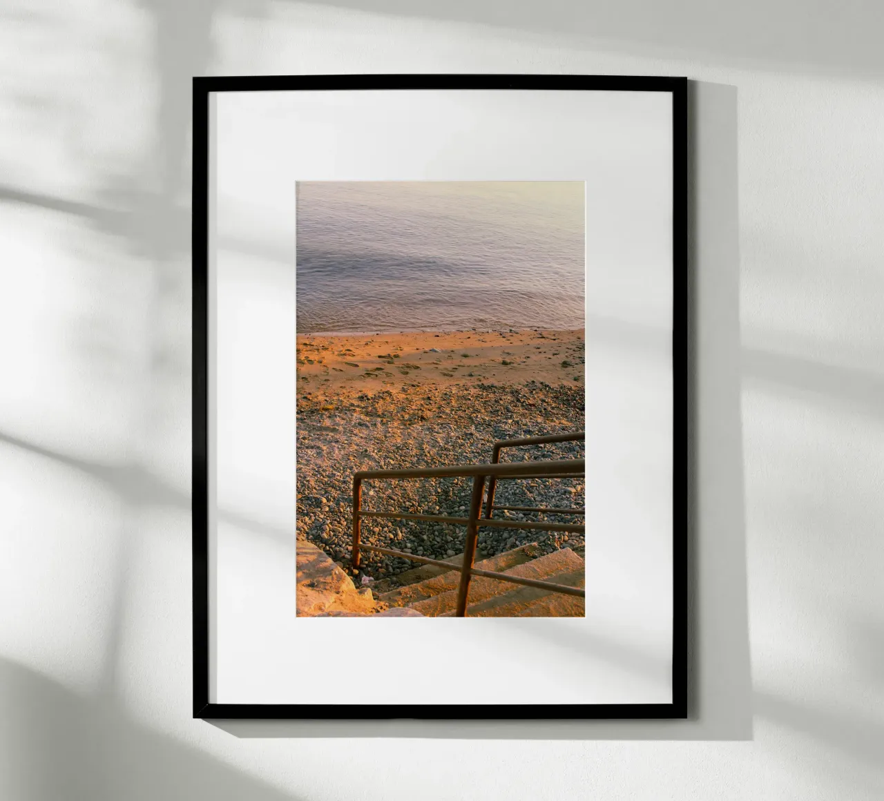 Scala rustica che conduce alla spiaggia di ciottoli al tramonto poster con telaio in alluminio da Liam Johnson