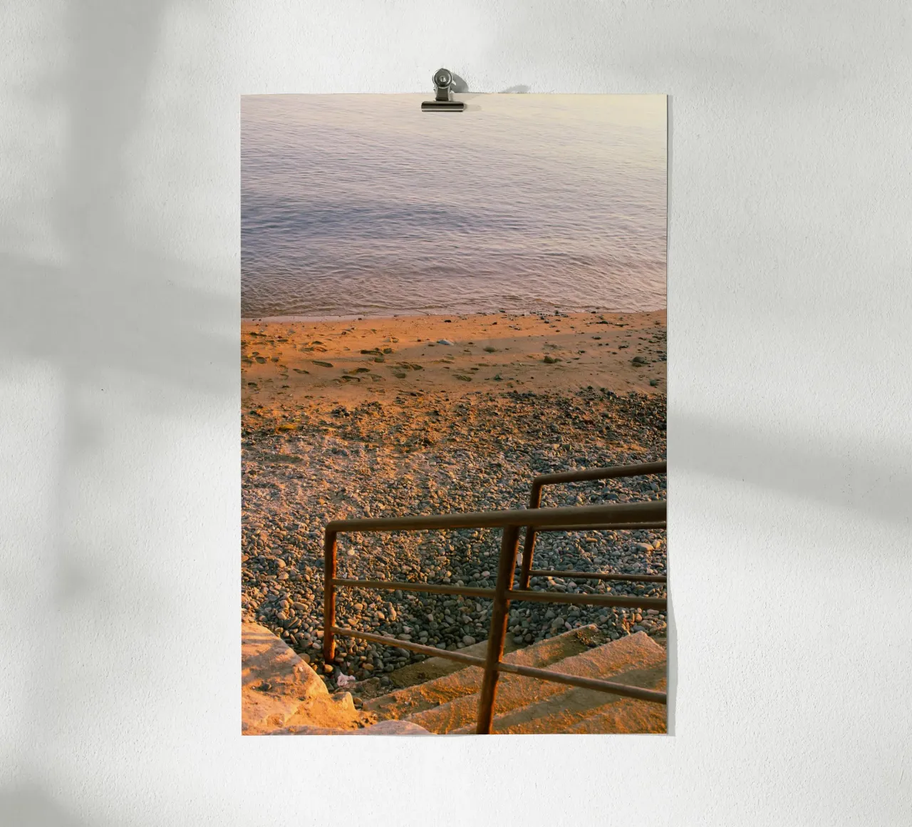 Scala rustica che conduce alla spiaggia di ciottoli al tramonto poster con telaio in alluminio da Liam Johnson
