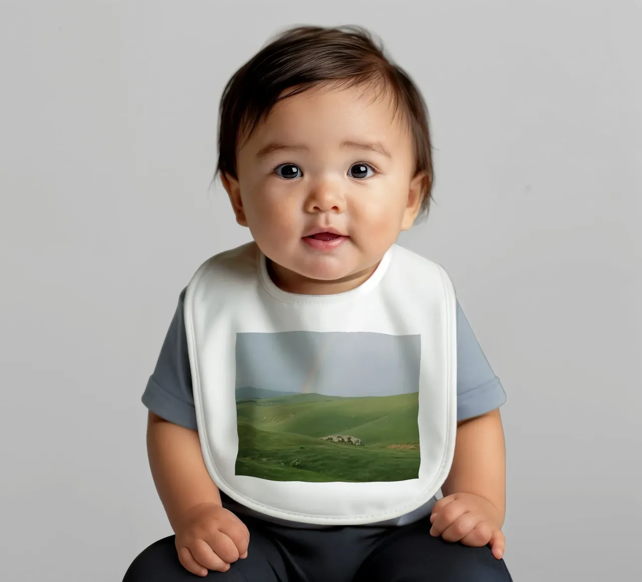 Colline verdi con arcobaleno e rocce bavaglino da DesignDoodle