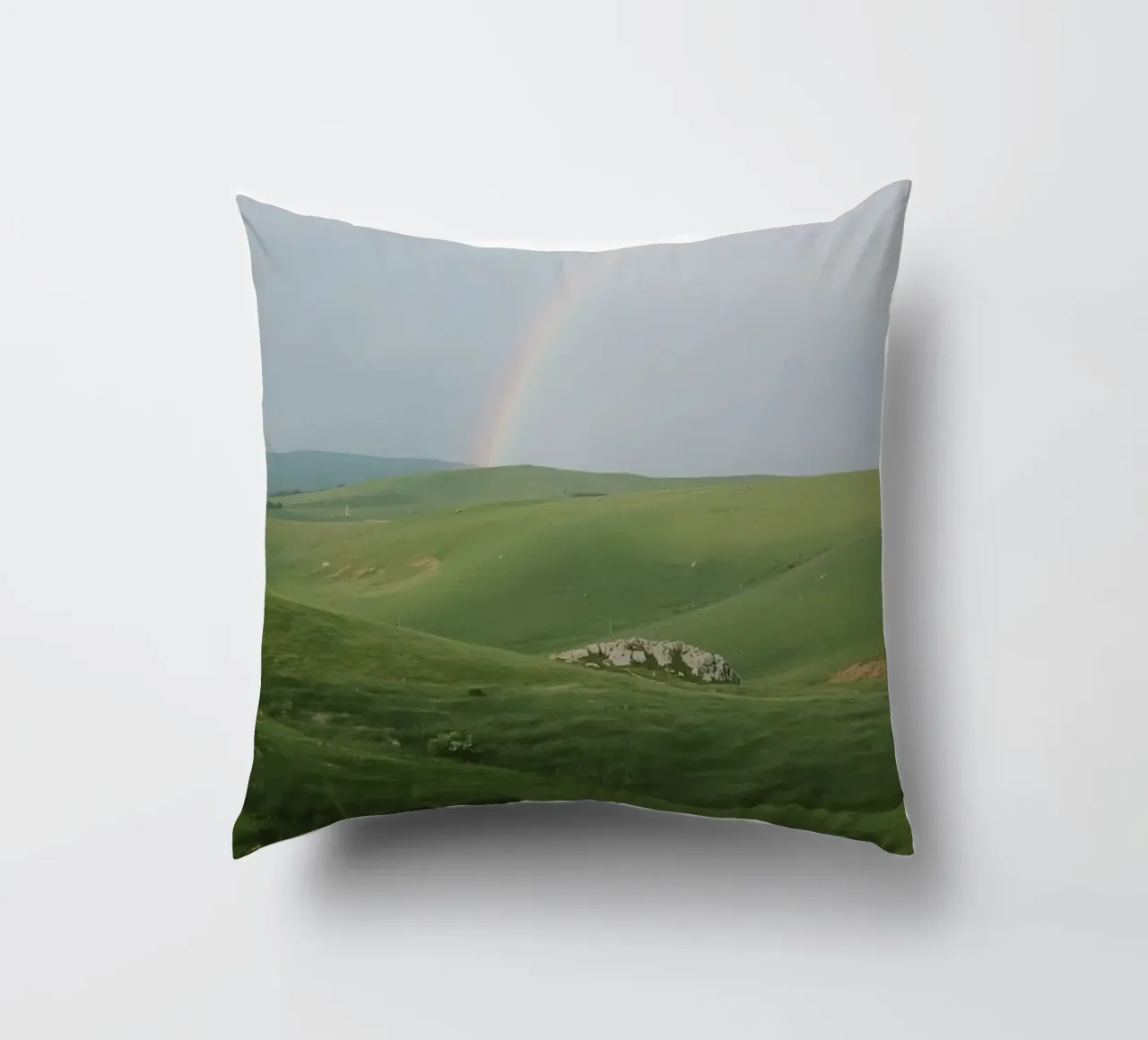 Colline verdi con arcobaleno e rocce cuscino da DesignDoodle