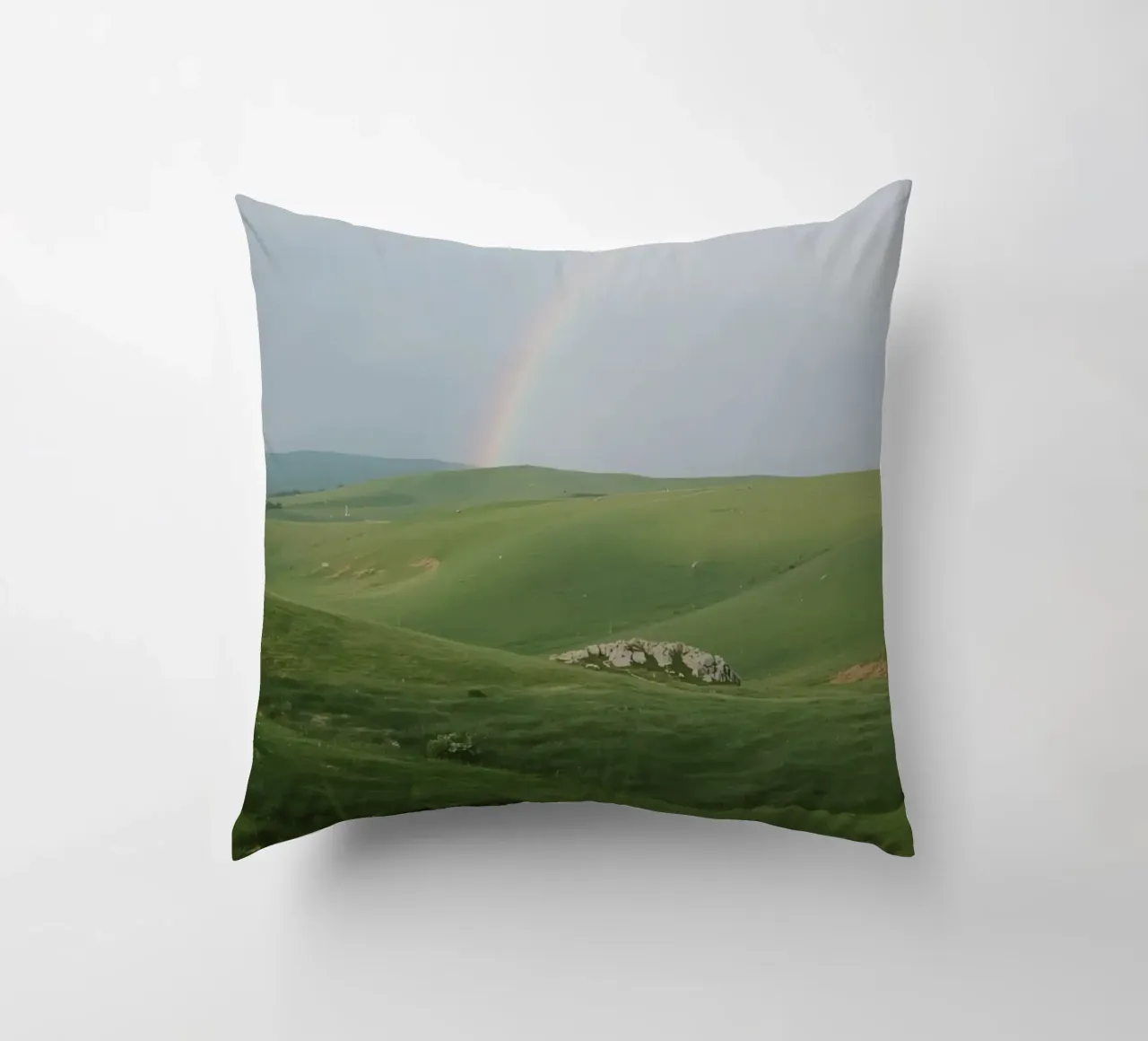 Colline verdi con arcobaleno e rocce cuscino da DesignDoodle