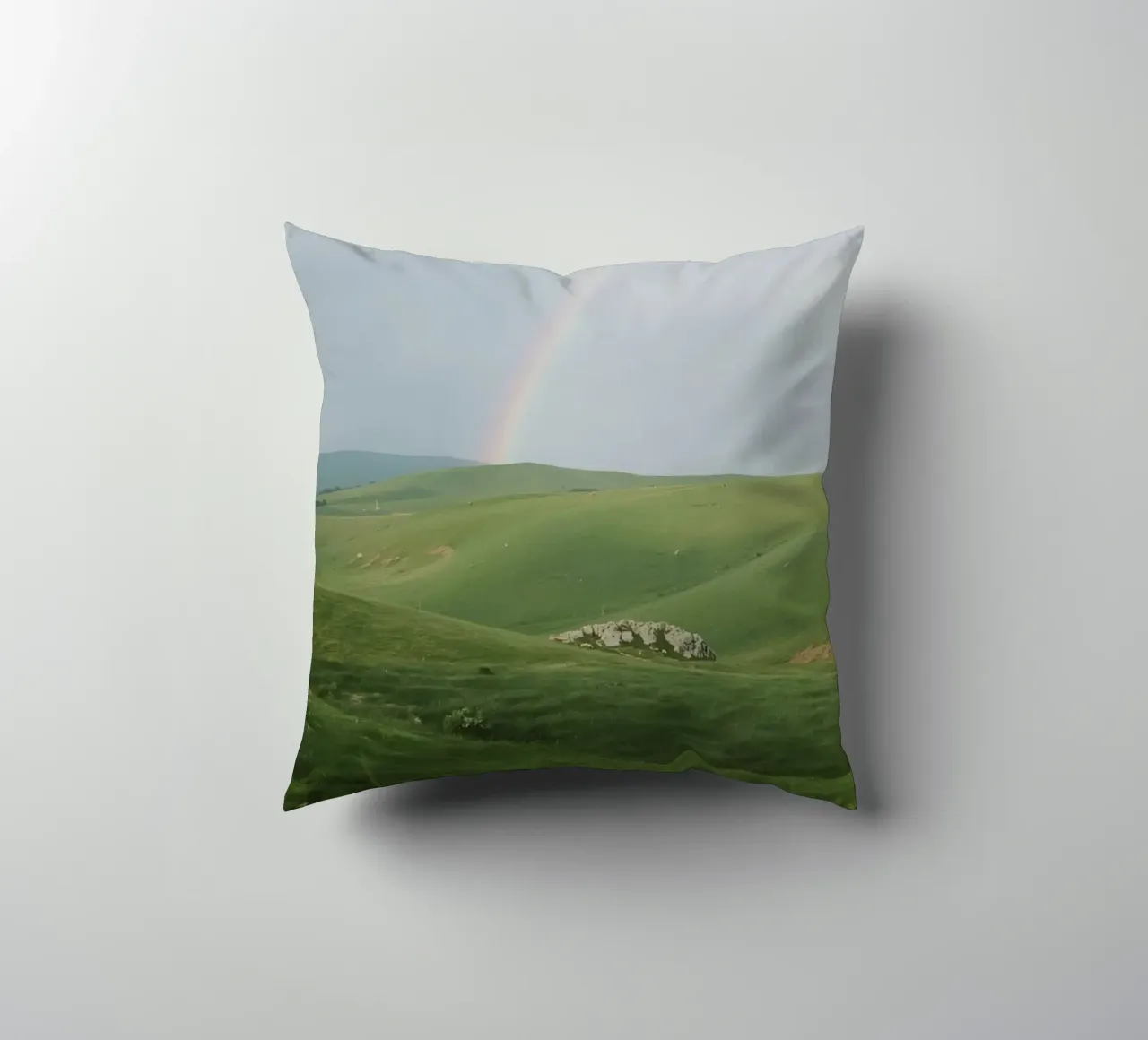 Colline verdi con arcobaleno e rocce cuscino da DesignDoodle