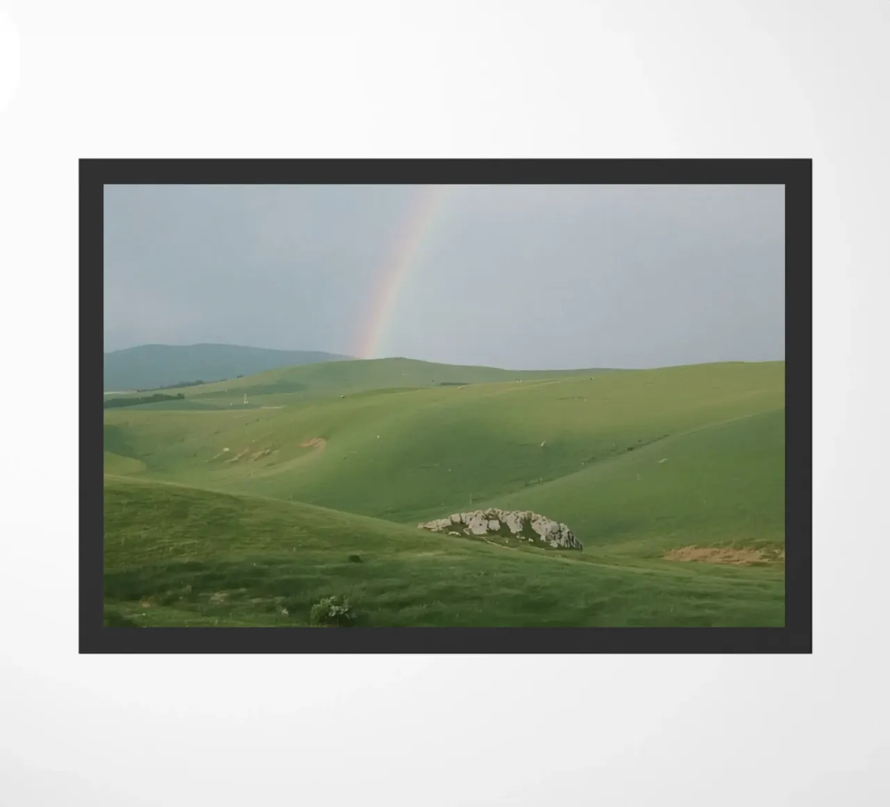 Colline verdi con arcobaleno e rocce zerbino da DesignDoodle