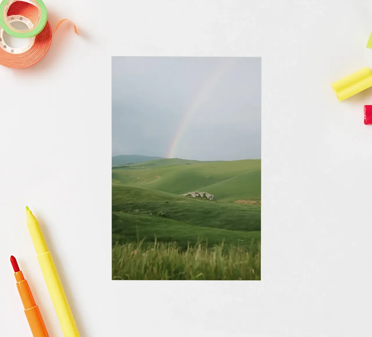 Colline verdi con arcobaleno e rocce adesivo da DesignDoodle