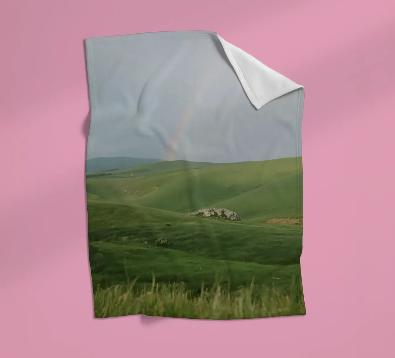 Colline verdi con arcobaleno e rocce coperta in pile da DesignDoodle