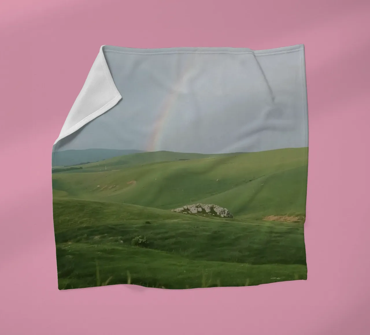 Colline verdi con arcobaleno e rocce coperta in pile da DesignDoodle